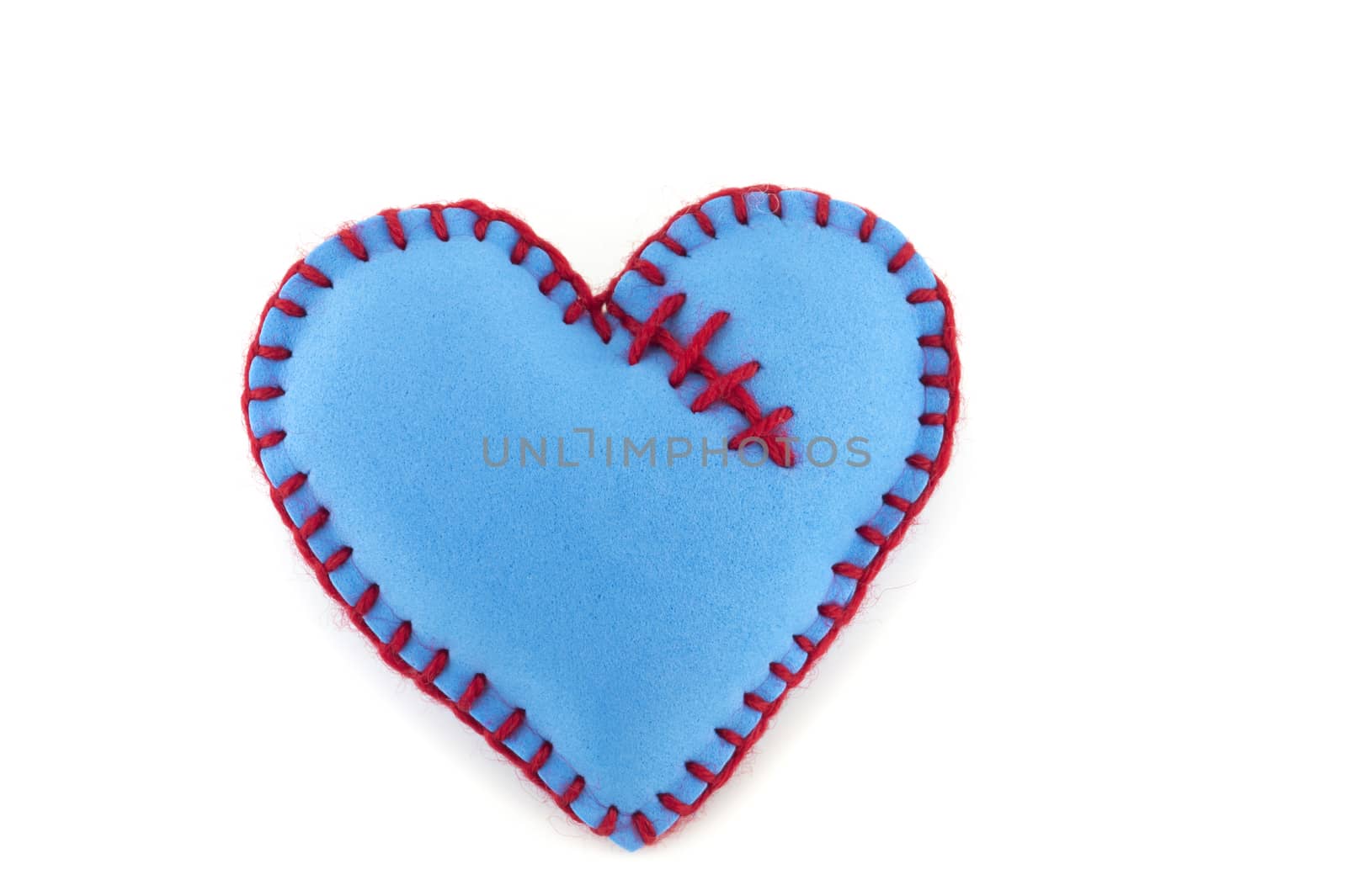 One handmade blue felt stitched toy heart on white background. Love, relationship, Valentines Day, broken heart concept