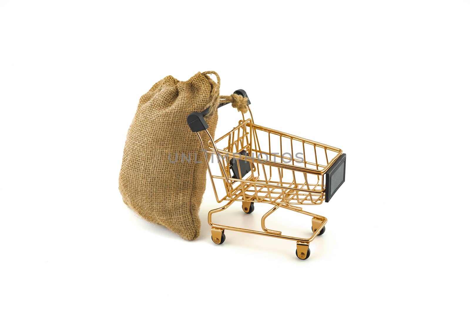 Empty golden shopping cart and jute bag isolated on white background