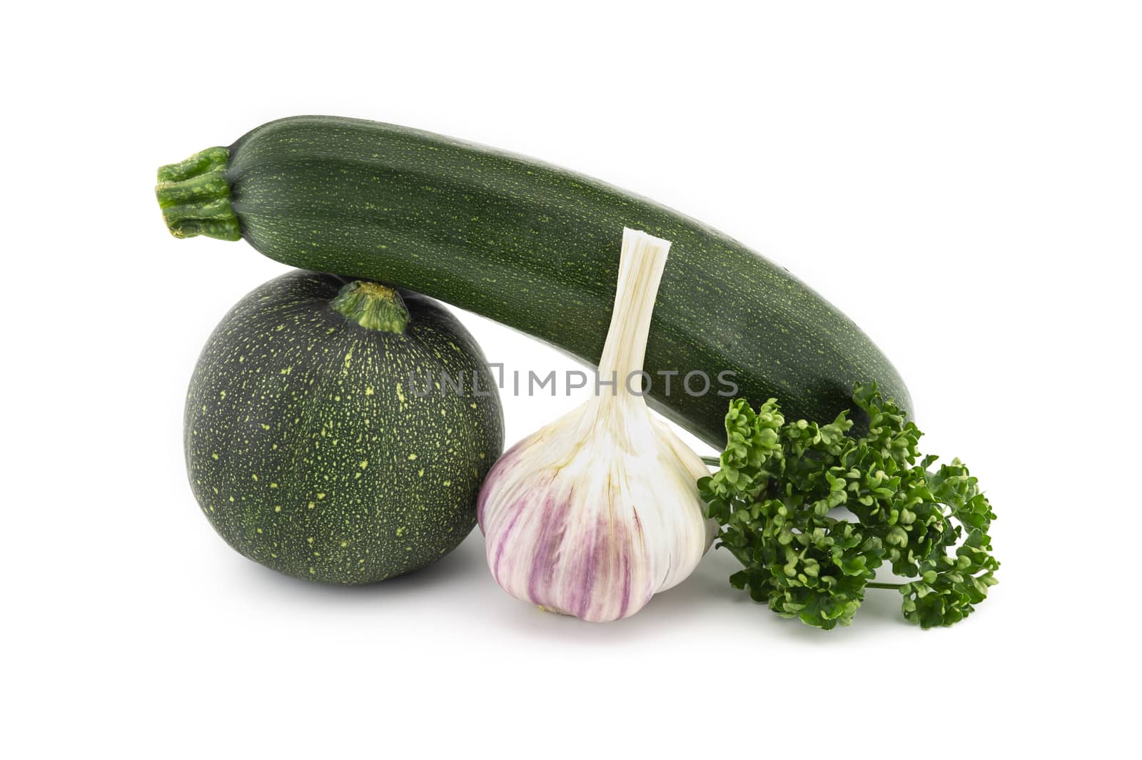 Green round and traditional courgette or zucchini, garlic knob and fresh parsley sprigs isolated on white background