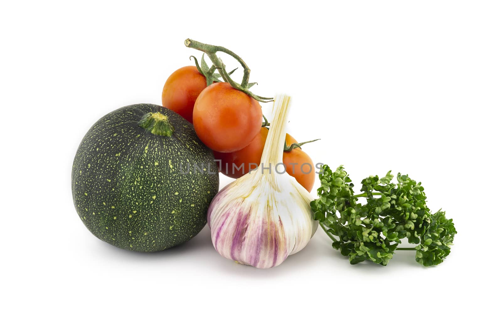 Green round courgette or zucchini, garlic knob, cherry tomato twig and fresh parsley sprigs isolated on white background