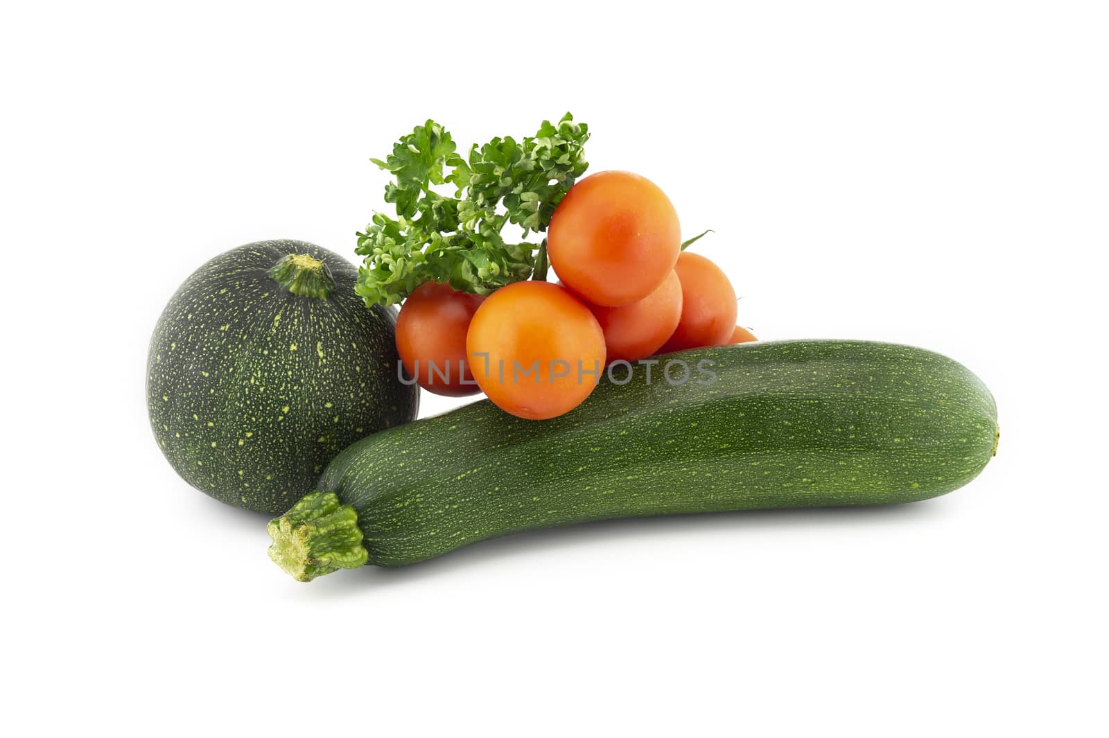 Green round and traditional courgette or zucchini, cherry tomato twig and fresh parsley sprigs isolated on white background