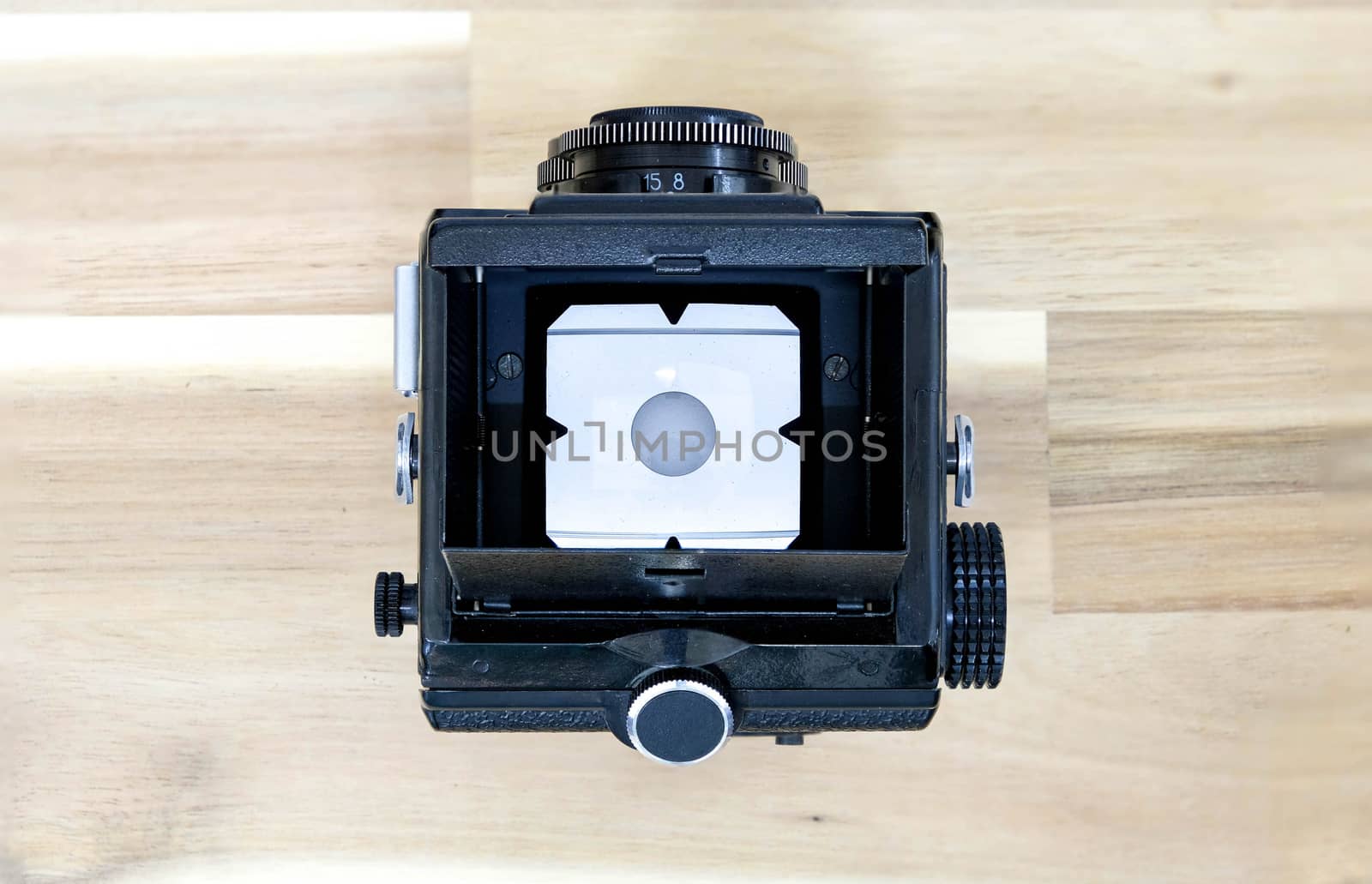 Top View of  Twin Lens Reflex Camera or TLR Film Camera  on Wooden Background with White Background on Focus Screen