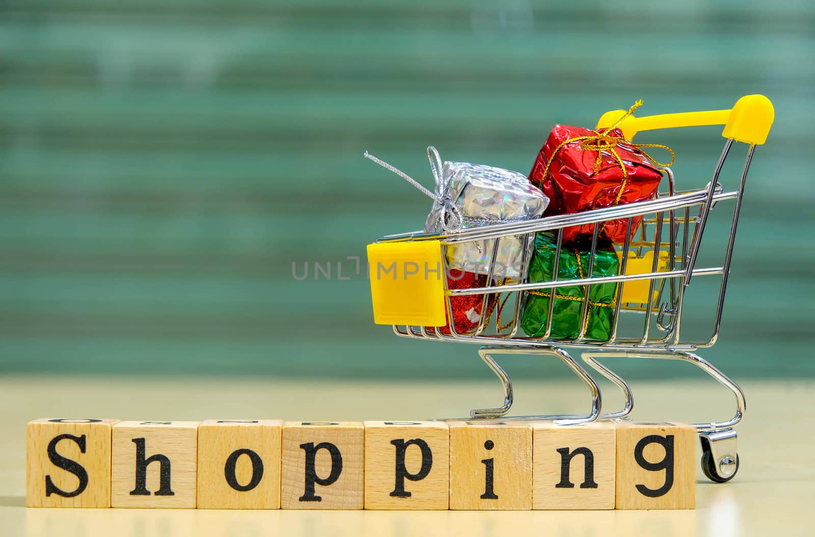 Wooden Alphabet words "shopping" and shopping cart with full of presents or gifts  in front of the Blur Shopping Store