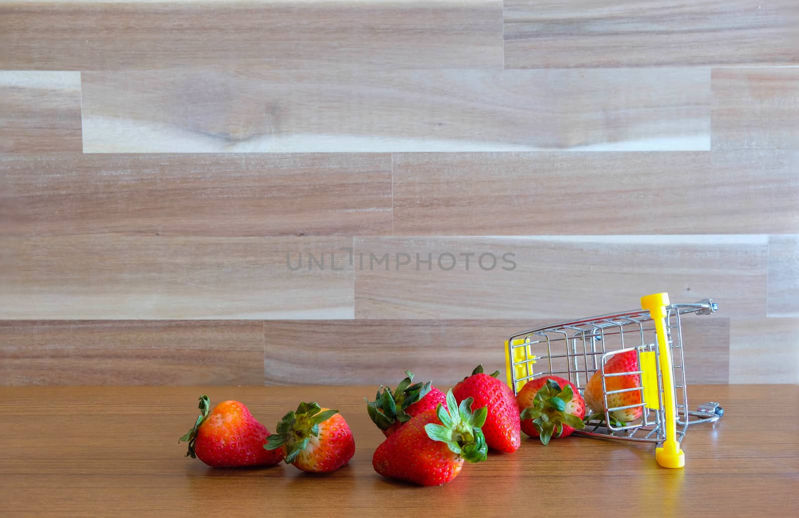 Close up strawberry on shopping cart with white and brown wooden background text advertising, diet food healthy food