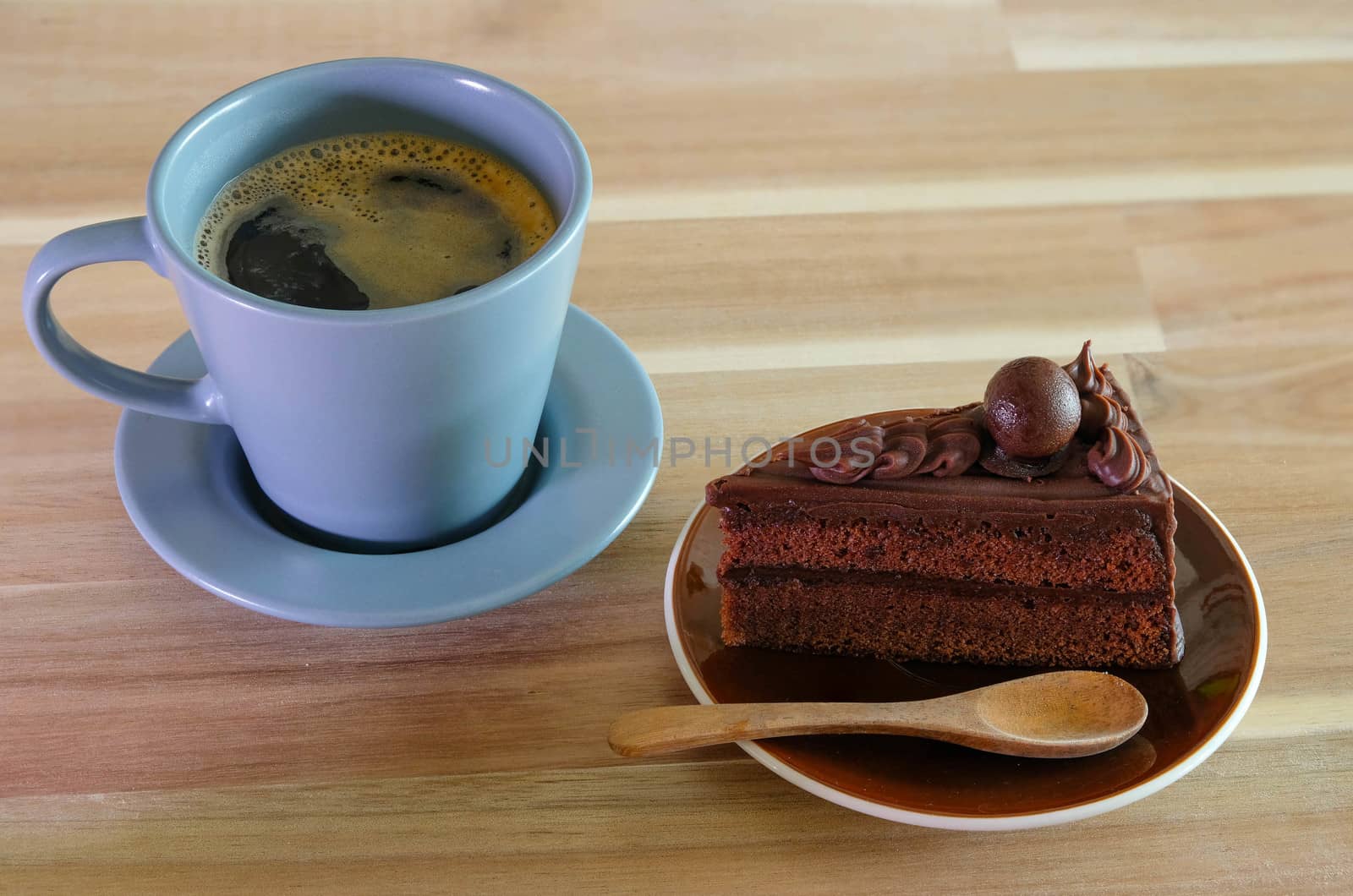 Chocolate cake and a cup of coffee on wooden table