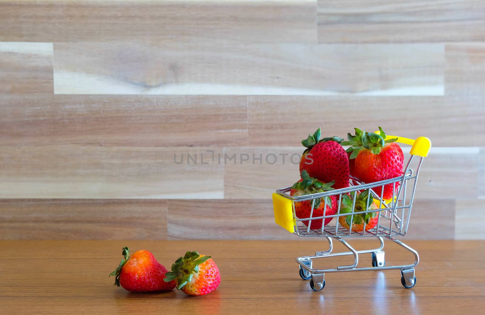 Close up strawberry on shopping cart with white and brown wooden by Bonn2210