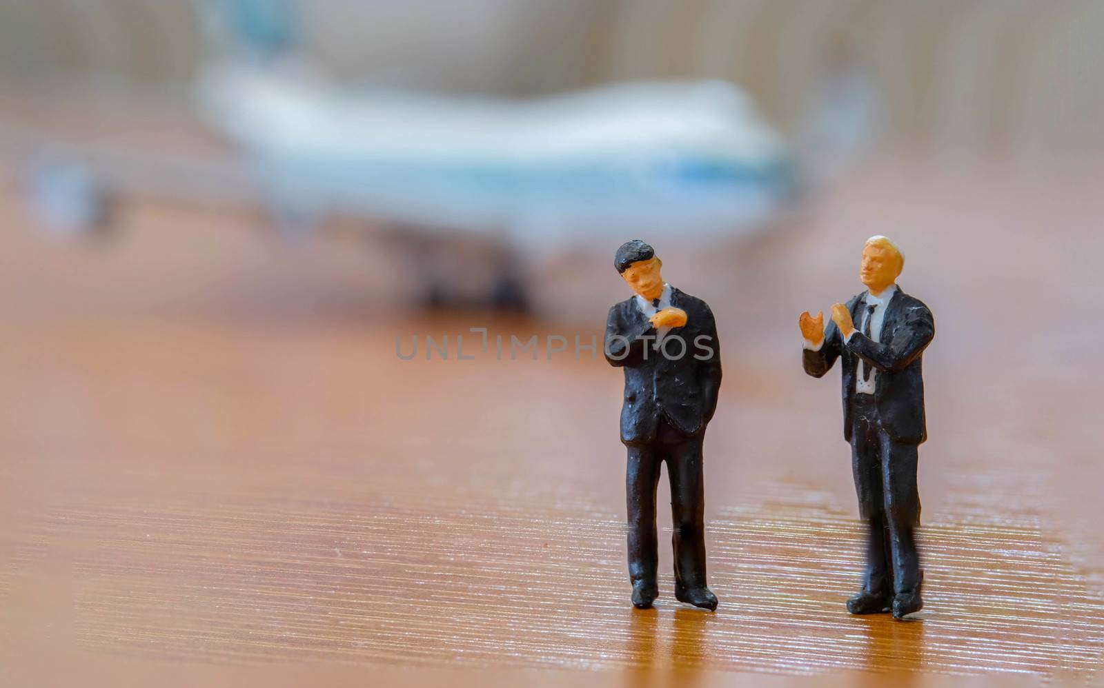 Planning and Global Business Concept. Close up of two businessman miniature figure standing in front of airplane
