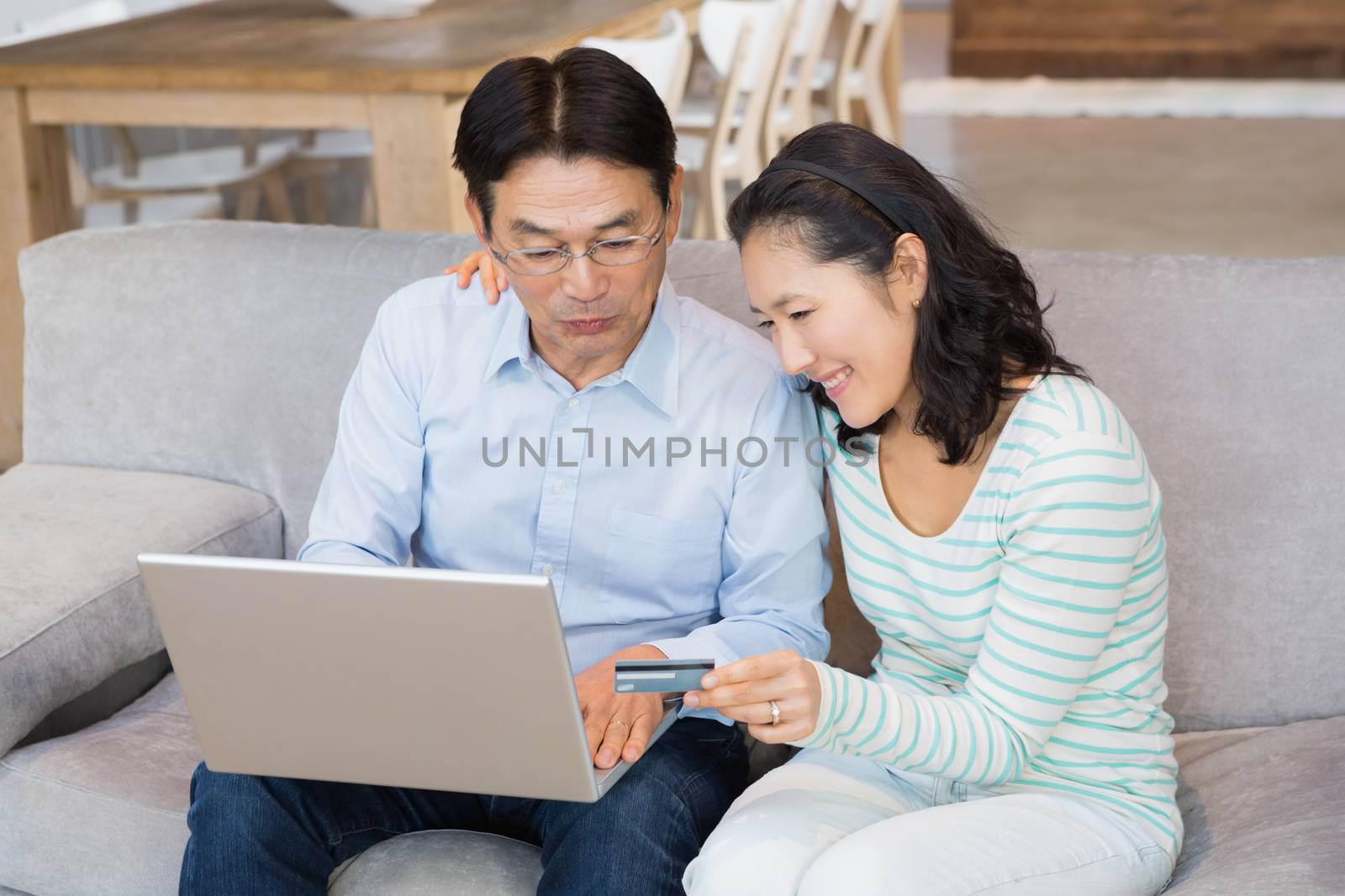 Happy couple shopping online on the sofa