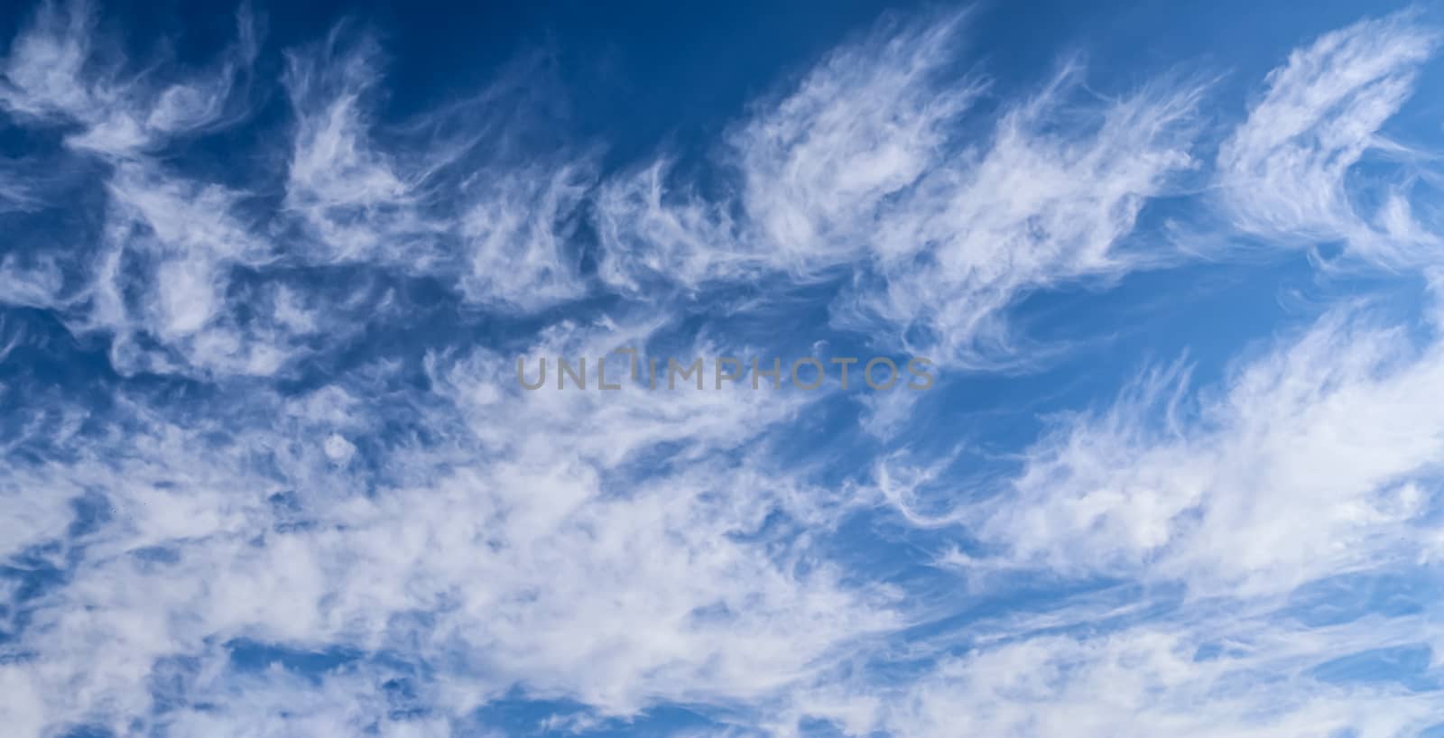 Stunning cirrus cloud formation panorama in a deep blue summer sky seen over Europe