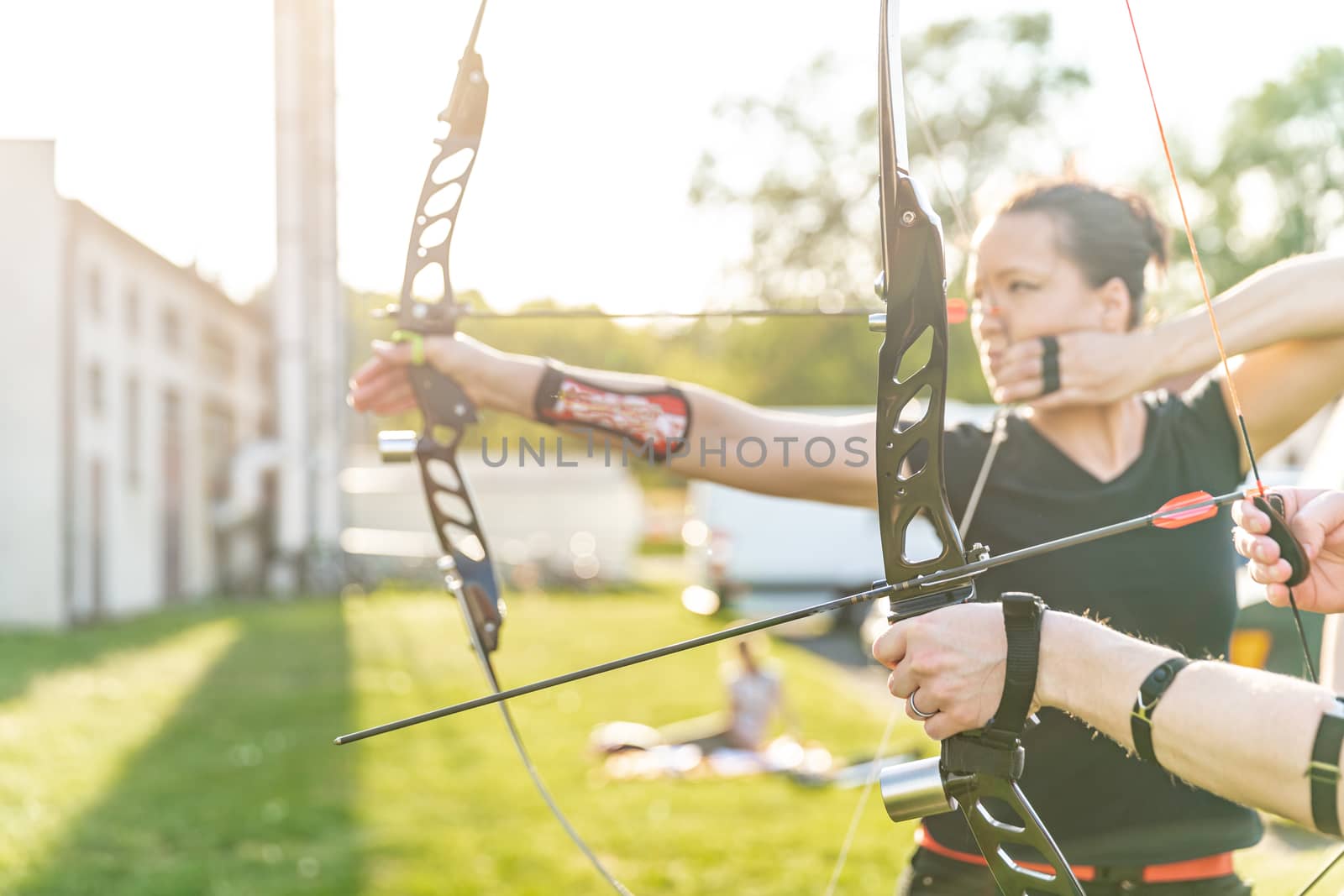 archery competition, woman preparing a bow and arrow to hit targets.