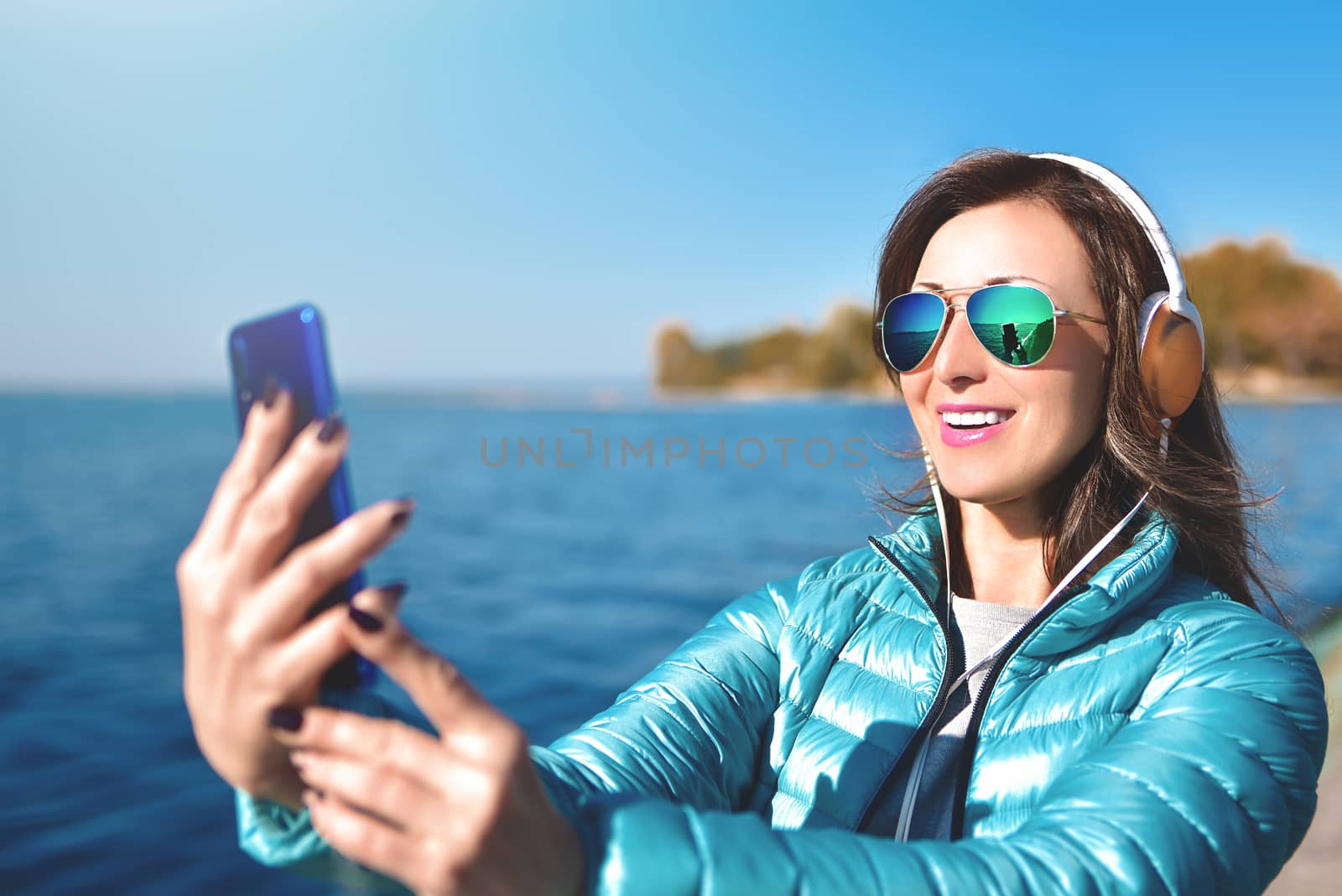 Happy joyful woman listening to music while being outdoor. Music concept.