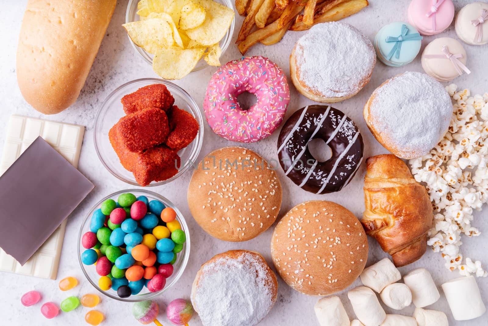 Unhealthy food and fast food with donuts, chocolate, burgers and sweets top view by Desperada