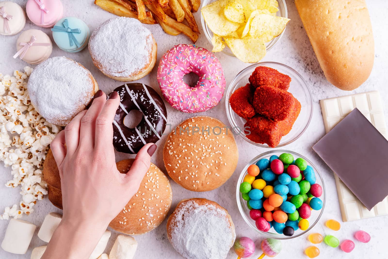 Fast food concept. Unhealthy food. Unhealthy food and fast food with donuts, chocolate, burgers and sweets top view