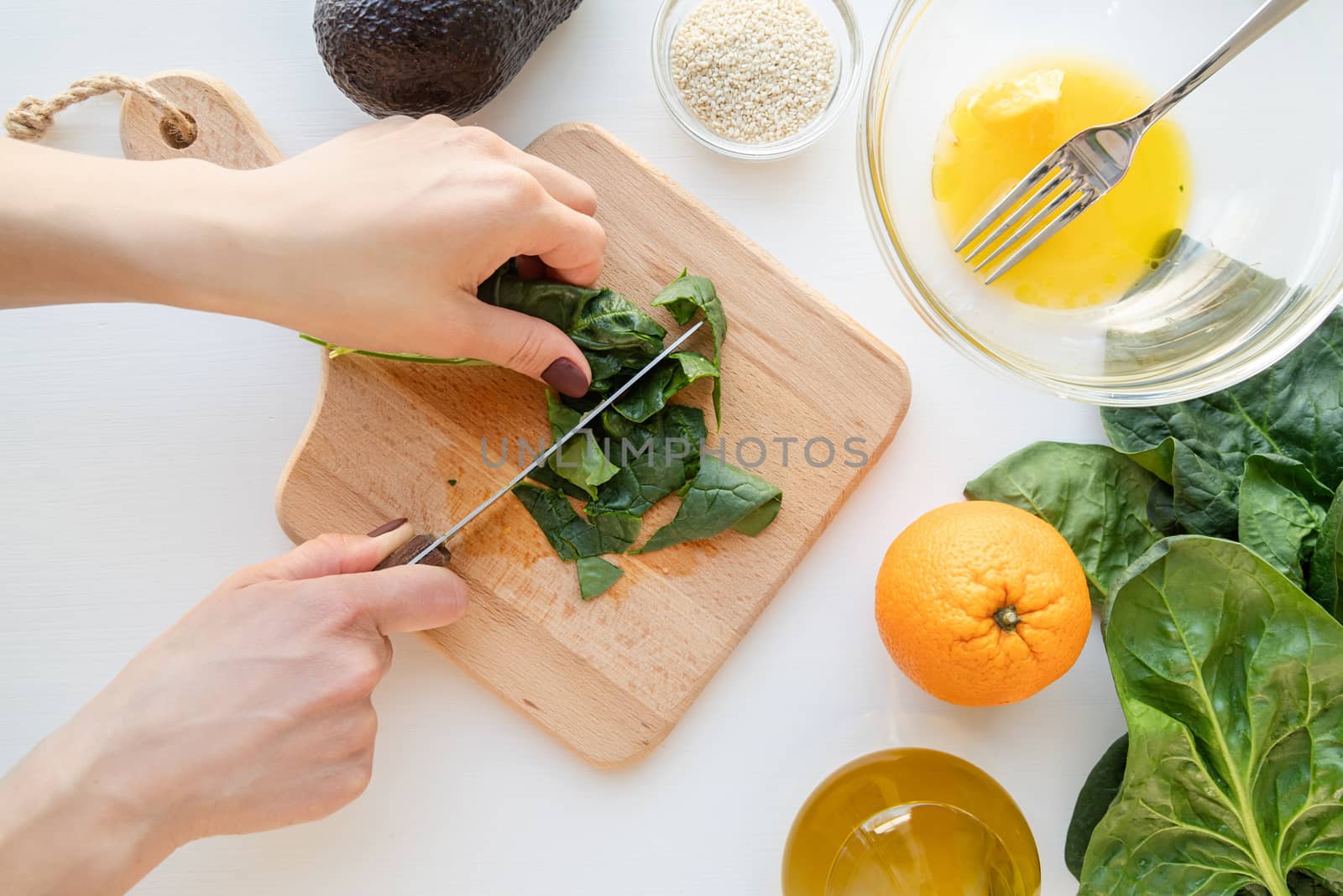 Step by step preparation of spinach, avocado and orange salad. Step 4 - cutting the spinach, top view, selective focus