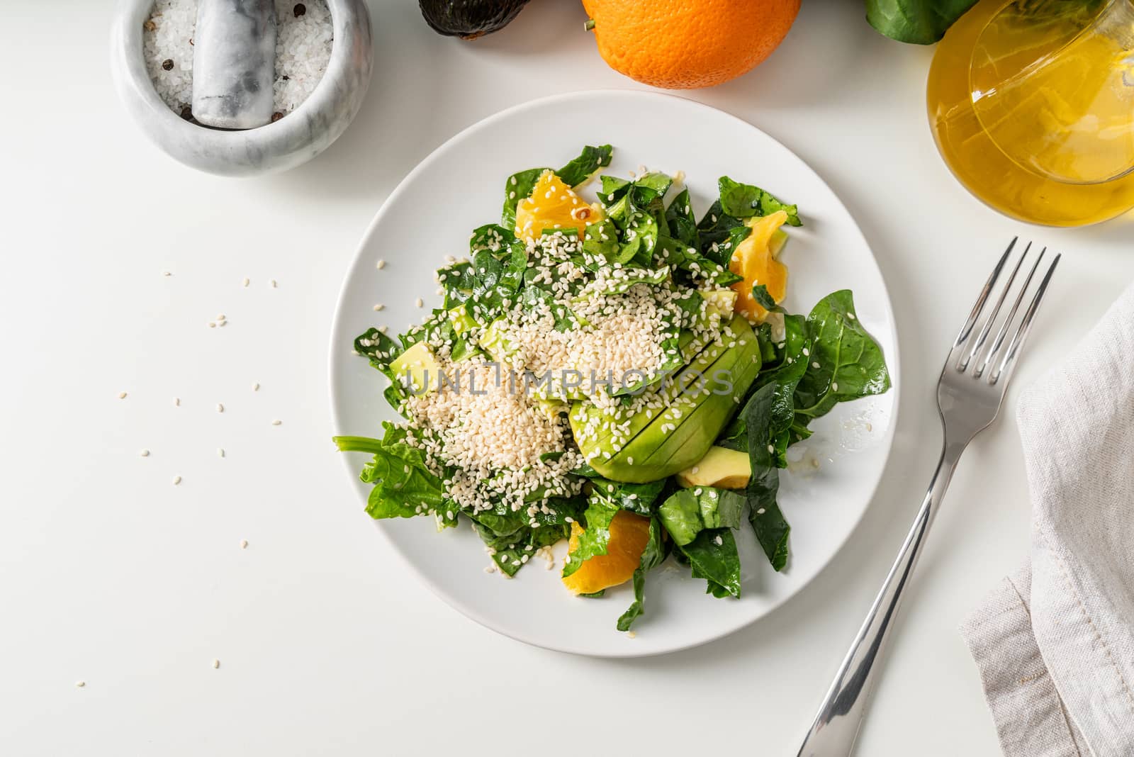 Healthy eating. Spinach, avocado and orange salad top view with copy space