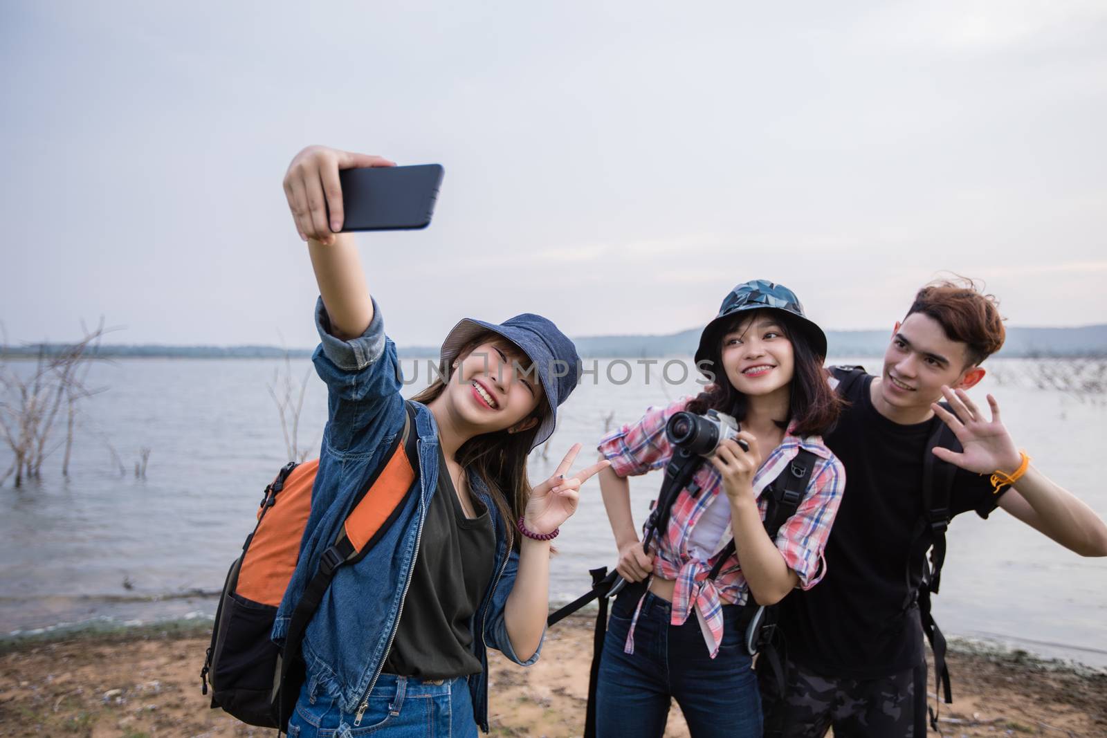 Asian Group of young people with friends and backpacks walking together and happy friends are taking photo and selfie ,Relax time on holiday concept travel by Tuiphotoengineer