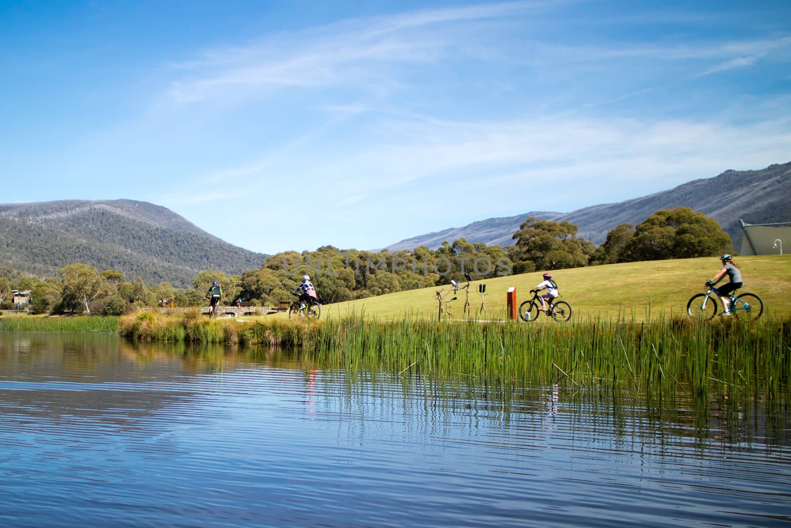 People cycling around Lake Crackenback on an autumn morning in New South Wales, Australia