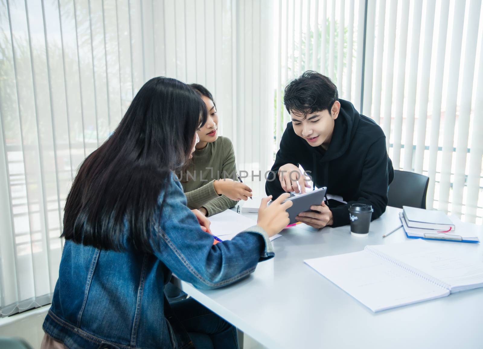 Asian students read books and use digital tablets to find information for work and online studies