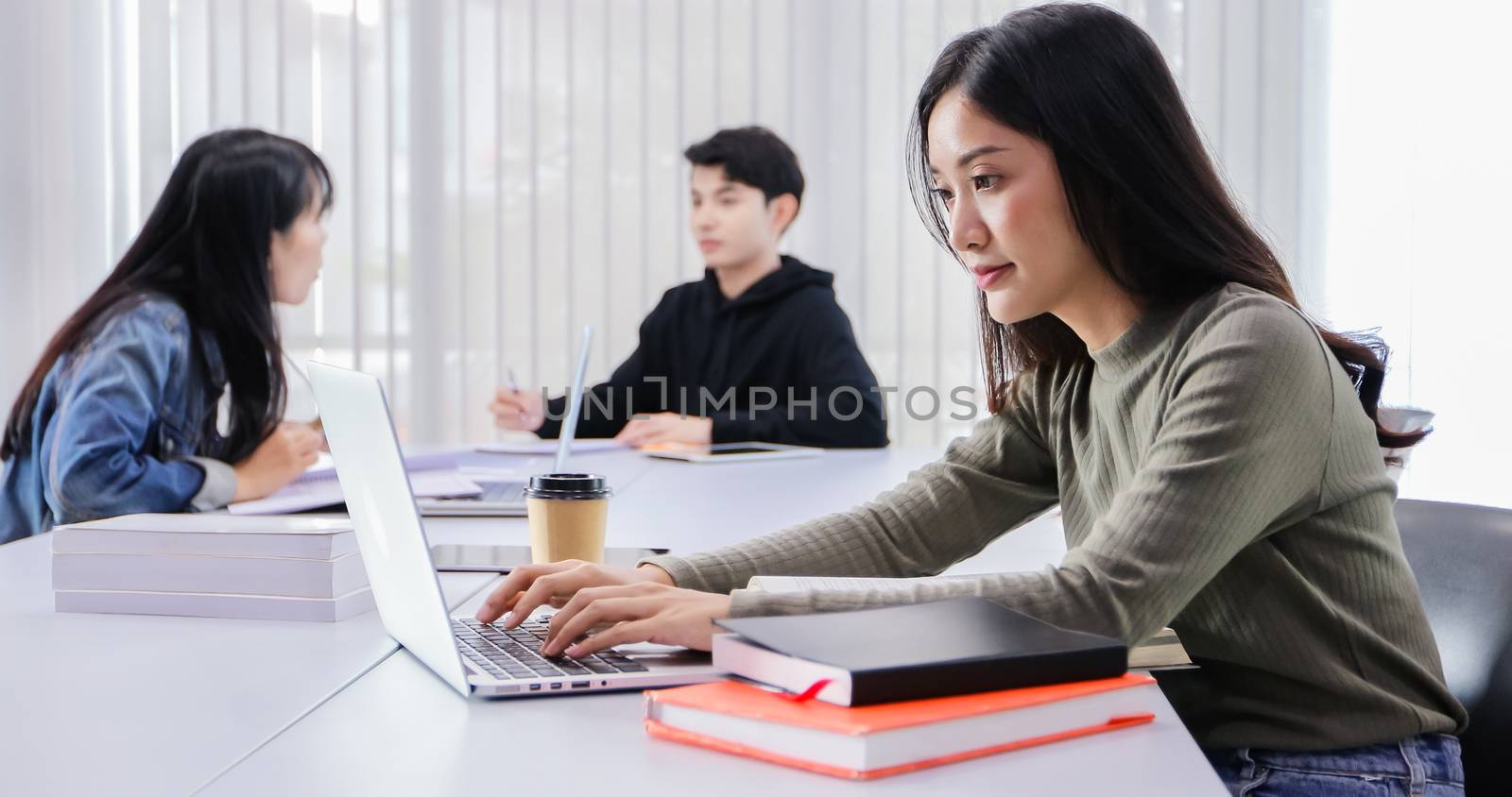 Asian women Students Smile and reading book and using notebook for working and sitting social distancing for infection risk