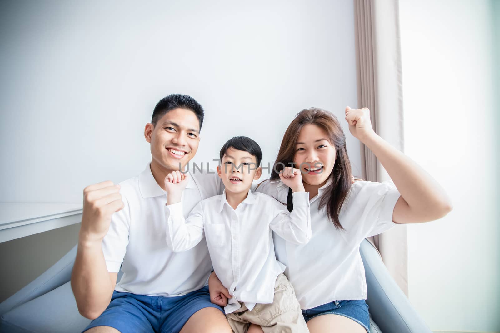 Excited and Happy family with arms raised while watching television at home