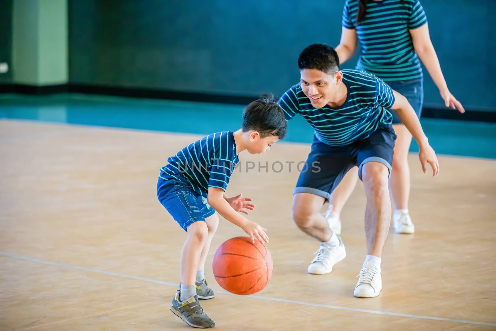 Asian family playing basketball together. Happy family spending free time together on holiday