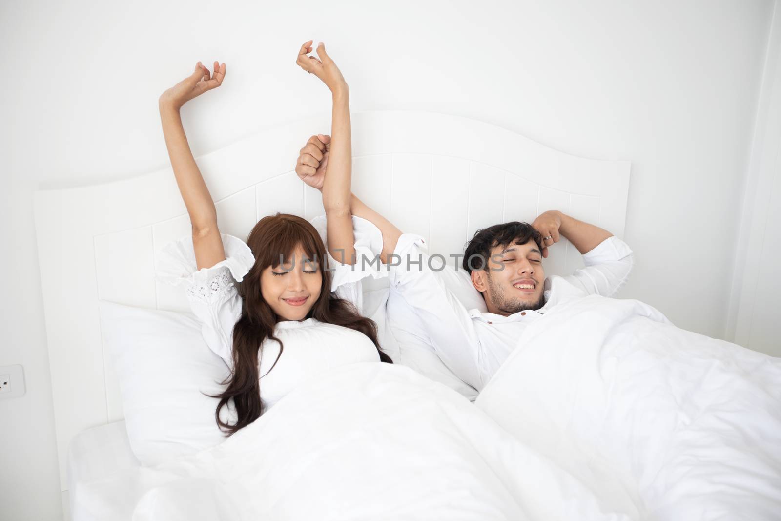 couples lover waking up in her bed fully rested and open the curtains in the morning to get fresh air.