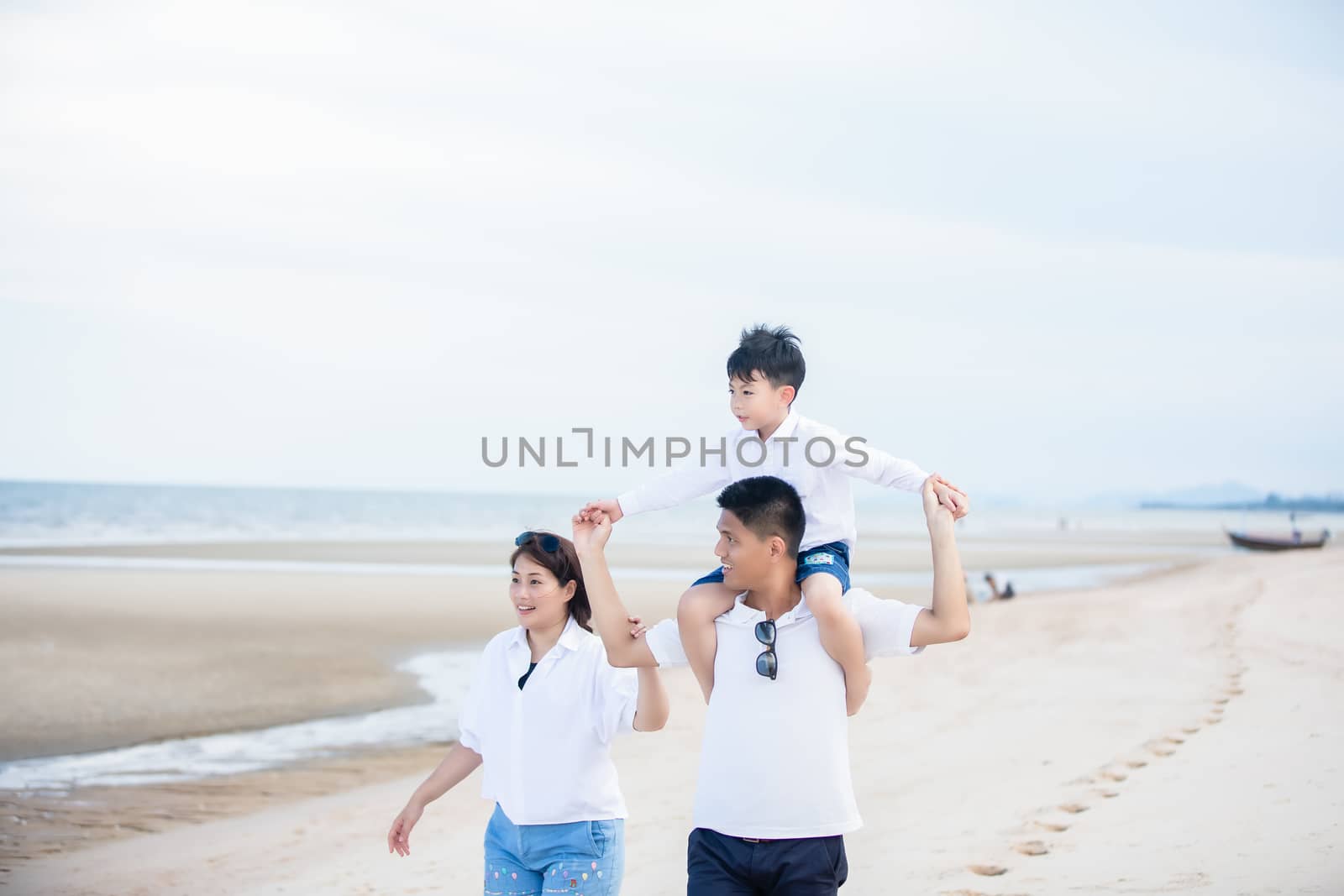 Active parents and people outdoor activity on summer vacations and holiday with children.Happy family and son walk with fun of sunset sea on sand beach.