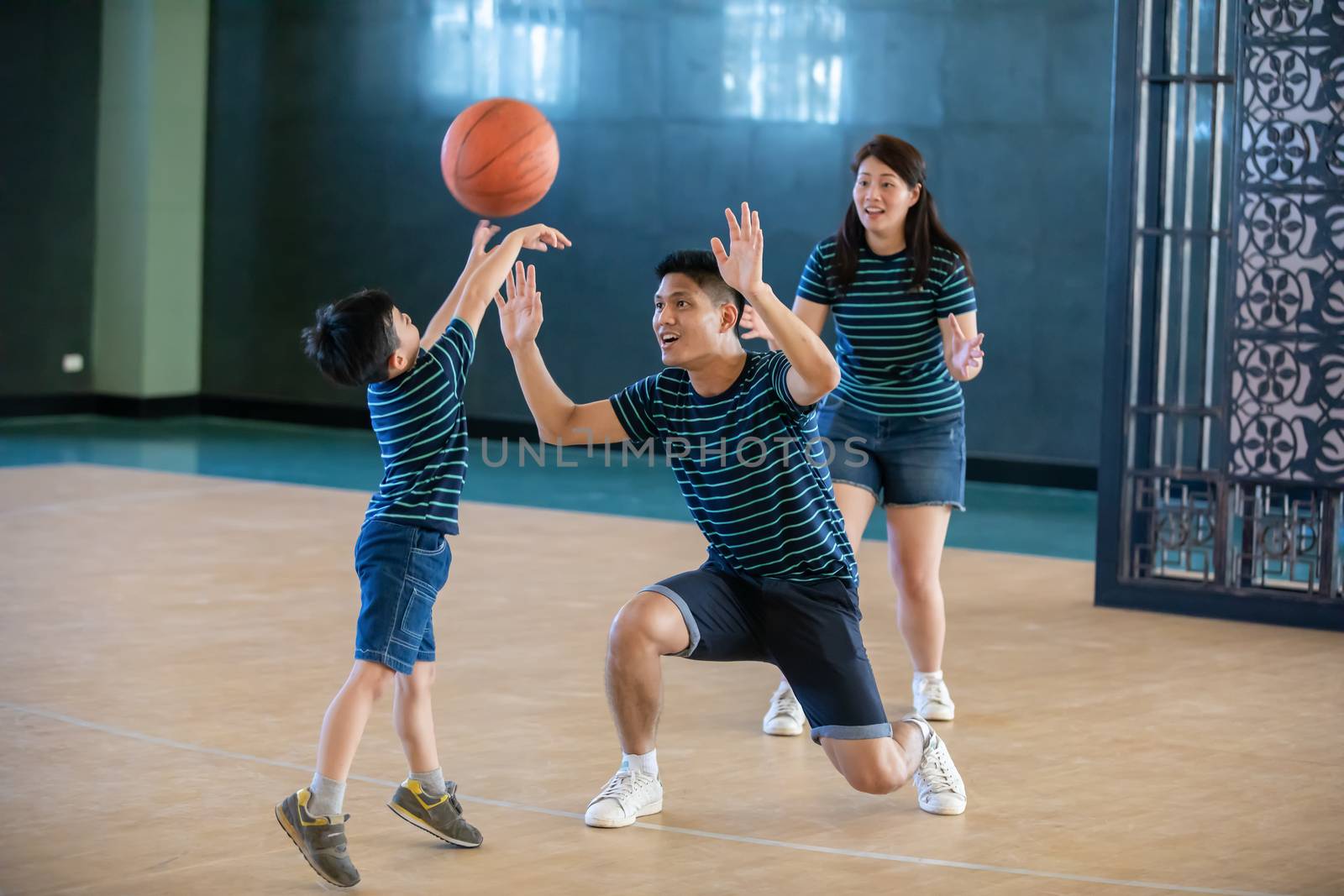 Asian family playing basketball together. Happy family spending free time together on holiday