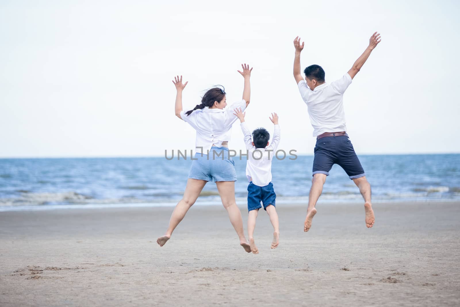 Active parents and people outdoor activity on summer vacations and holiday with children.Happy family and son walk with fun of sunset sea on sand beach.