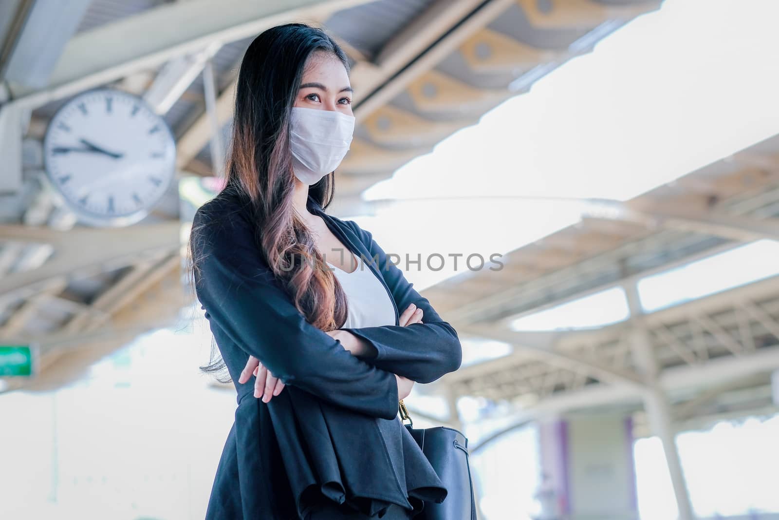 Business girl with hygiene mask stand on platform for waiting the sky train by nrradmin
