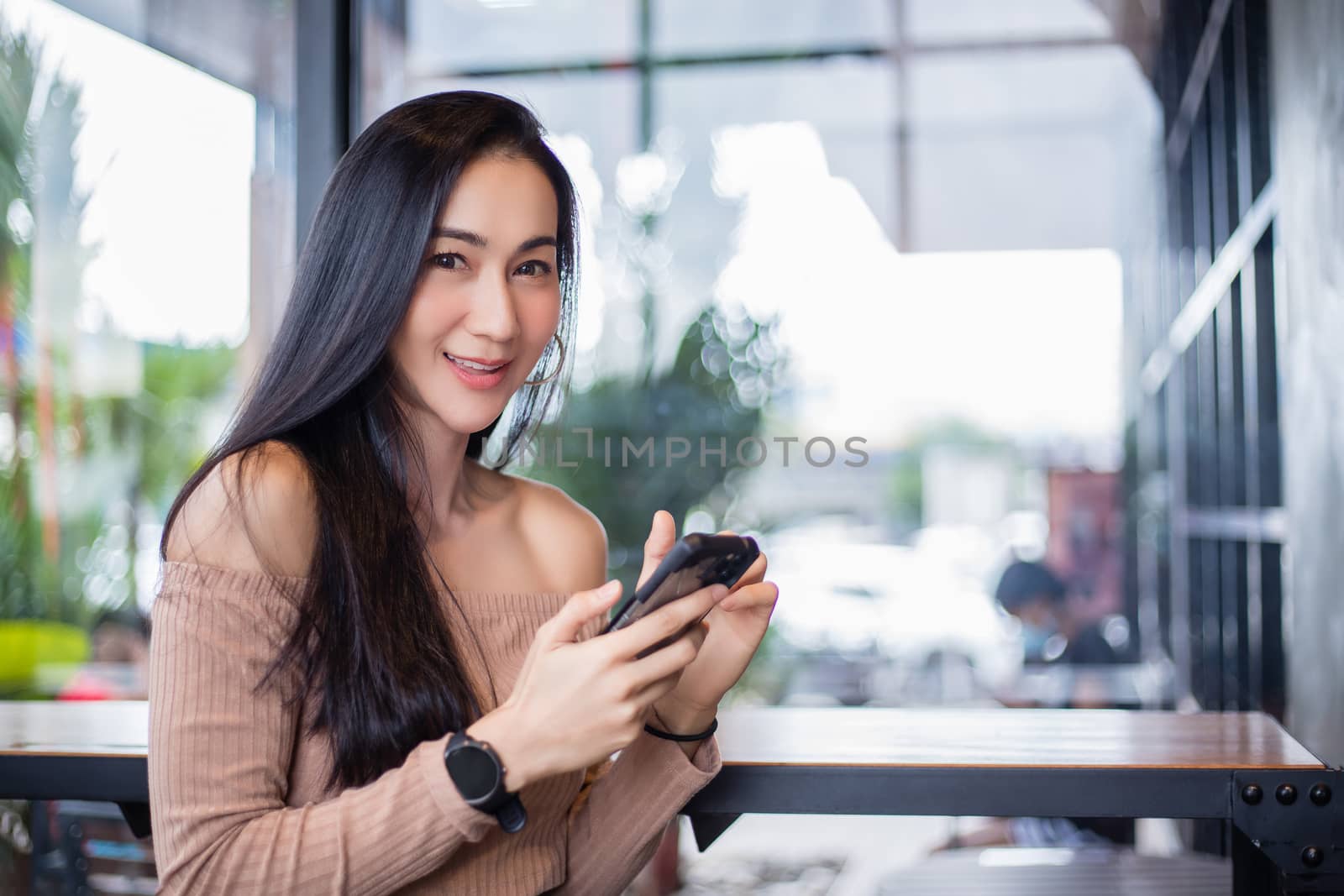 Smiling and happy Asian Business women are using mobile and touch smart phone for Communication and search for information .Technology communication lifestyles concept. by Tuiphotoengineer