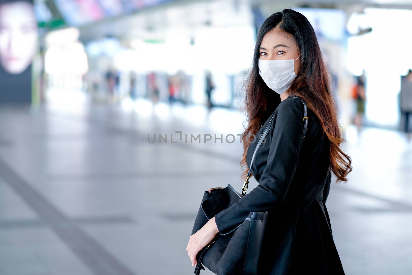 Portrait of business woman with hygiene mask stand in the station of sky train by nrradmin