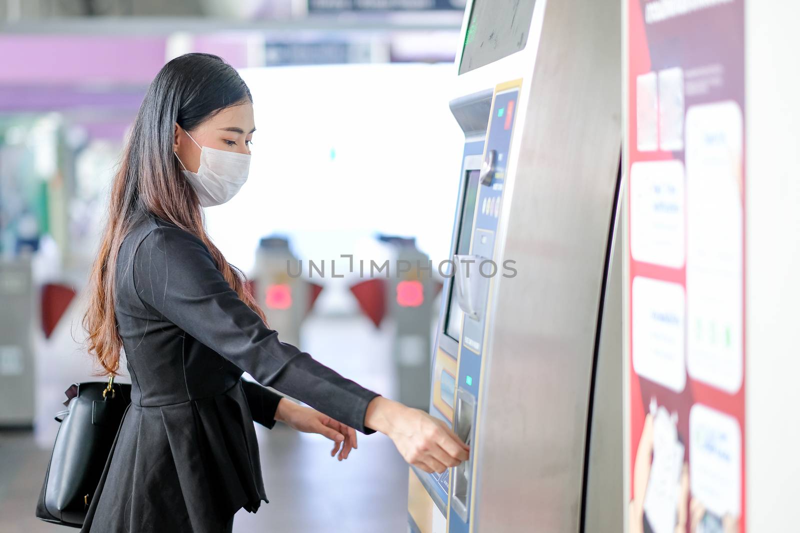 Beautiful girl with hygiene mask buy the ticket of sky train at the station by nrradmin