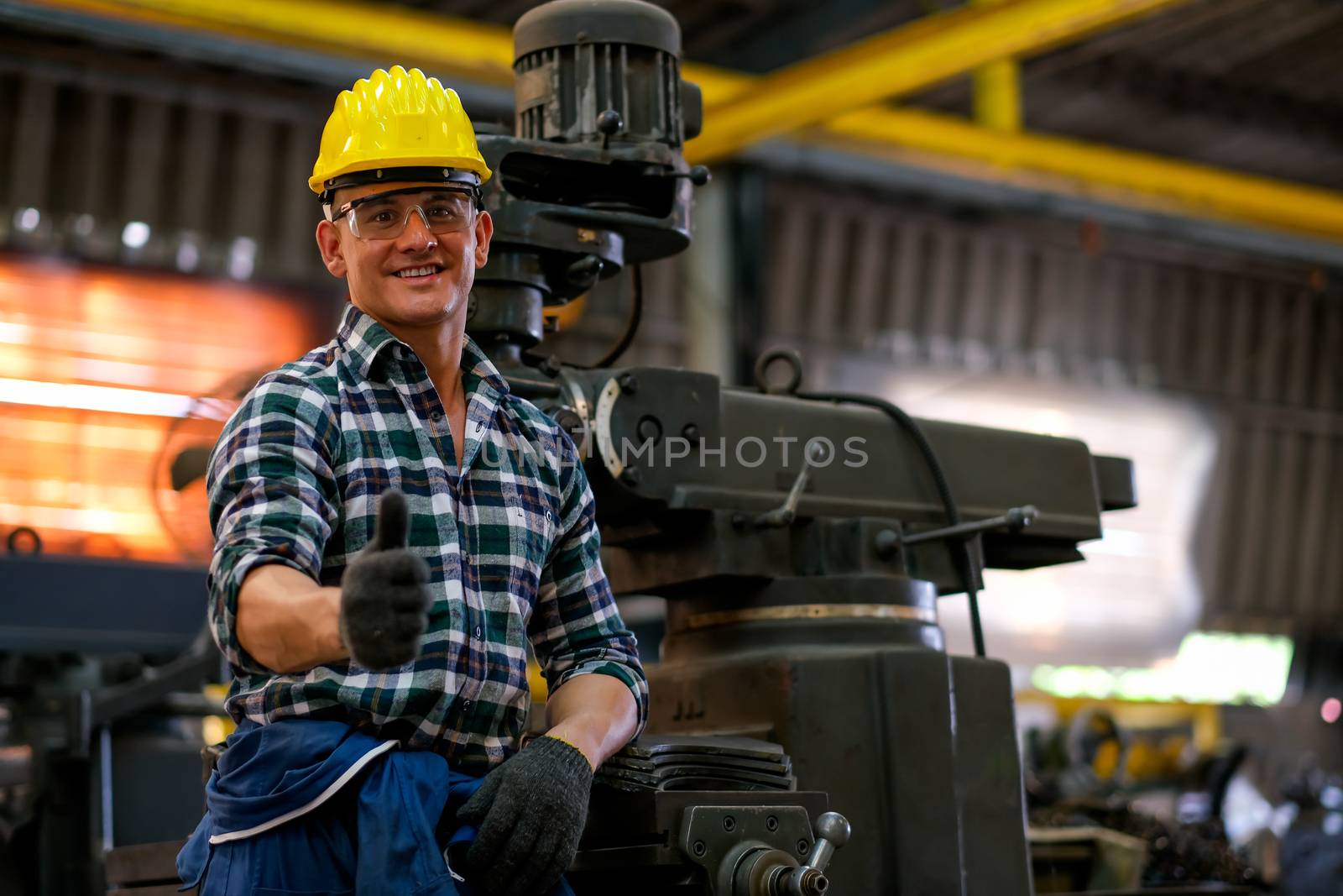 Front view of smart technician or engineer worker with protective helmet stand with confident and thumbs up by nrradmin