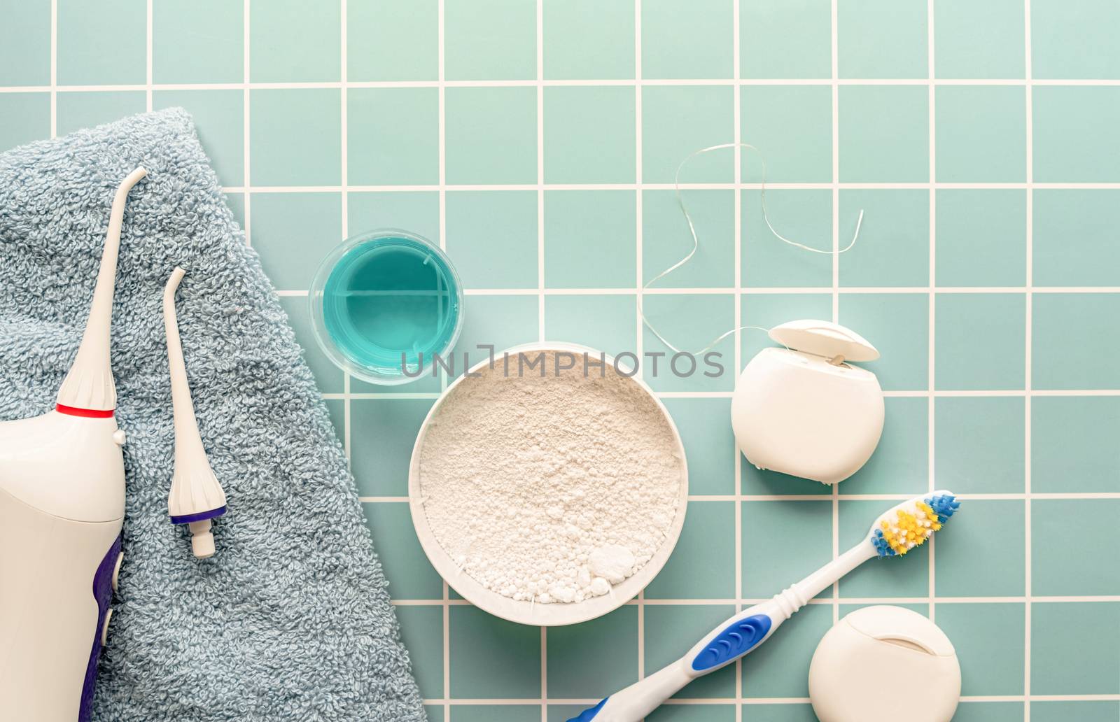 Oral hygiene, dental tools, dental floss, mouth irrigator, toothbrushes and dental powder top view on blue background