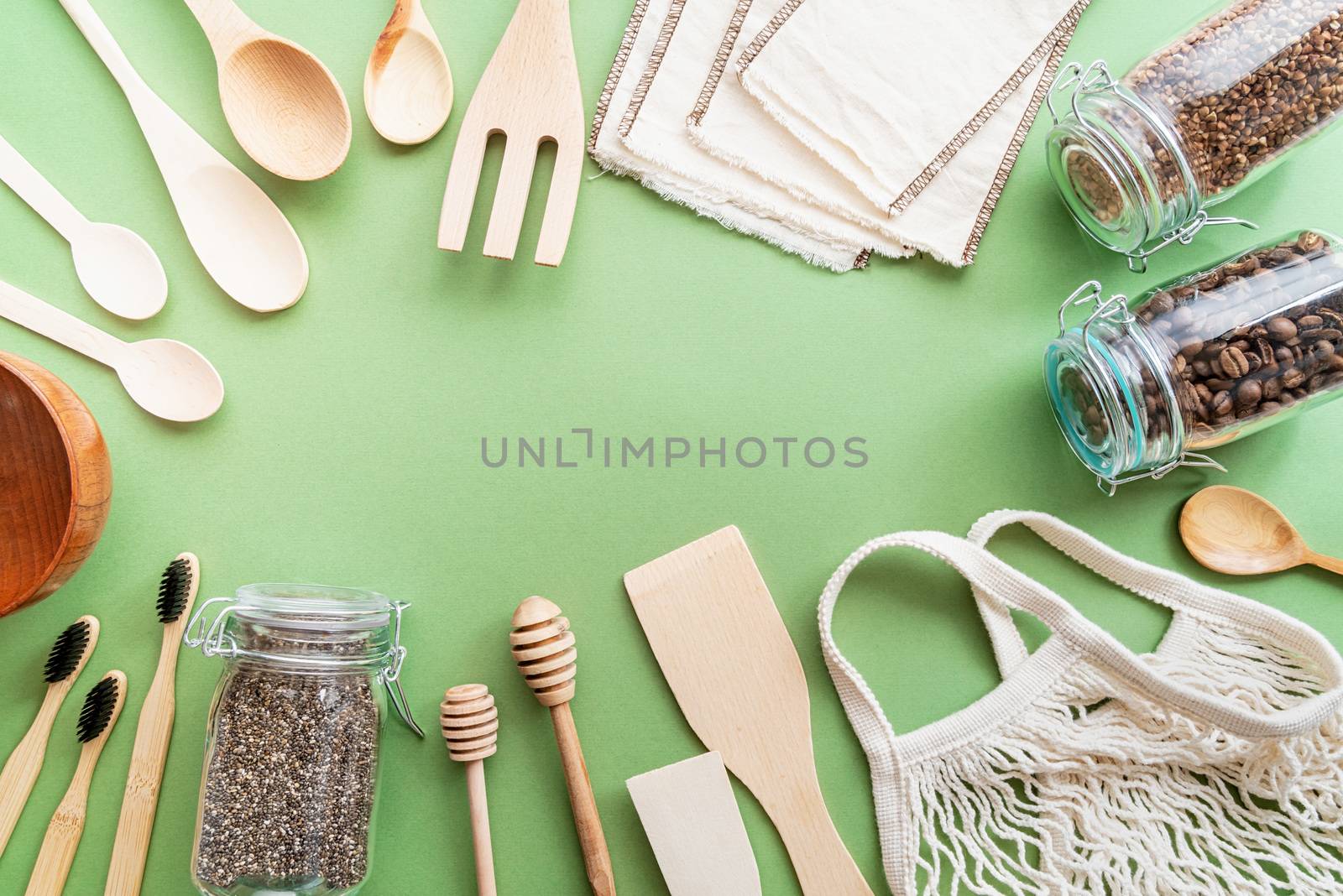 Zero waste eco friendly bag and wooden tools top view on green background by Desperada
