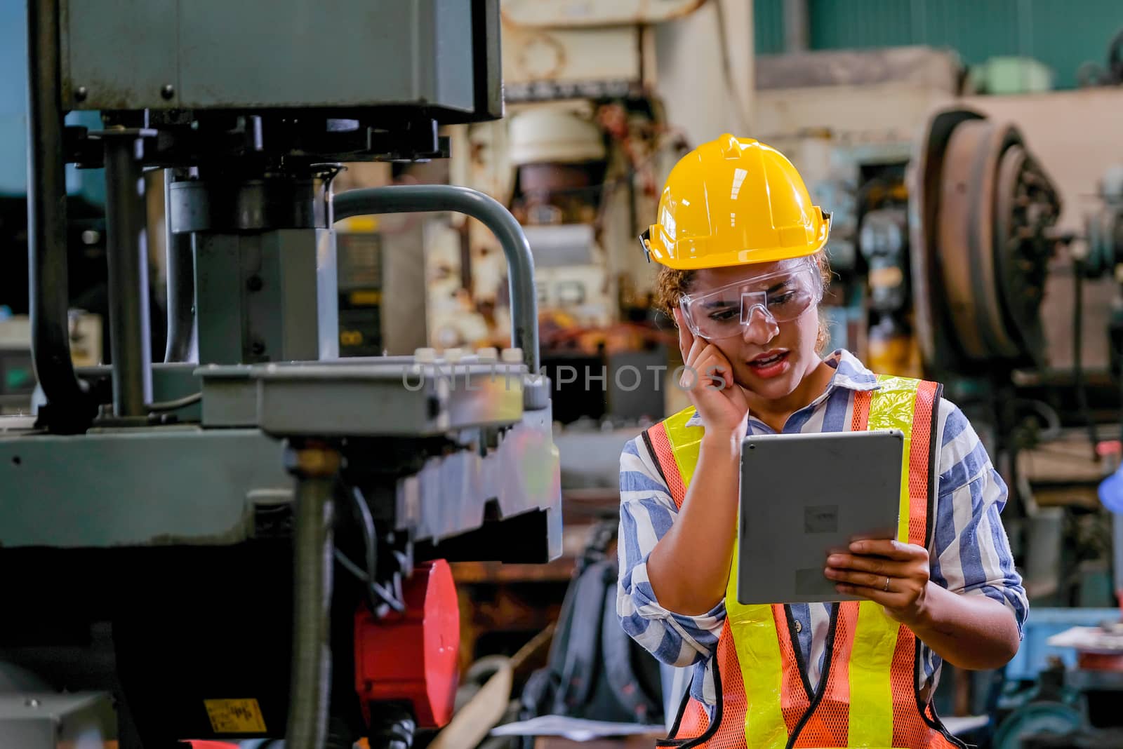 Technician woman with tablet check or maintenance the machine in factory.