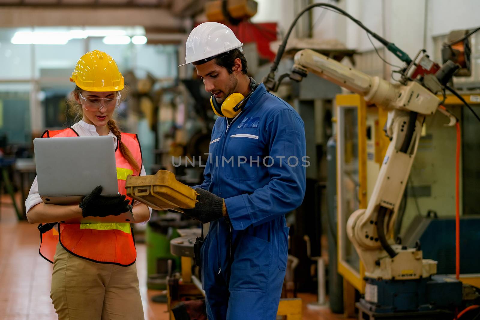 Technician or worker man and woman discussion about robot working in factory by nrradmin