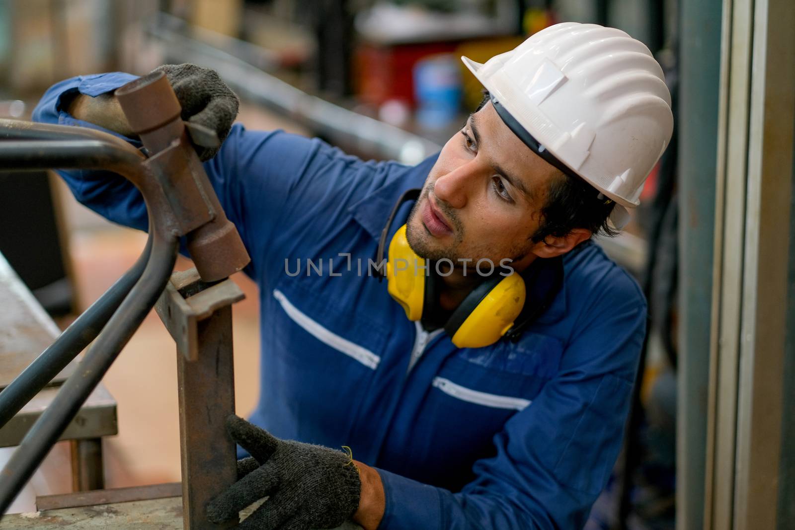 Technician or worker man with blue uniform fix the problem of metal part of equipment in factory. Concept of good system and manager support for better industrial business.