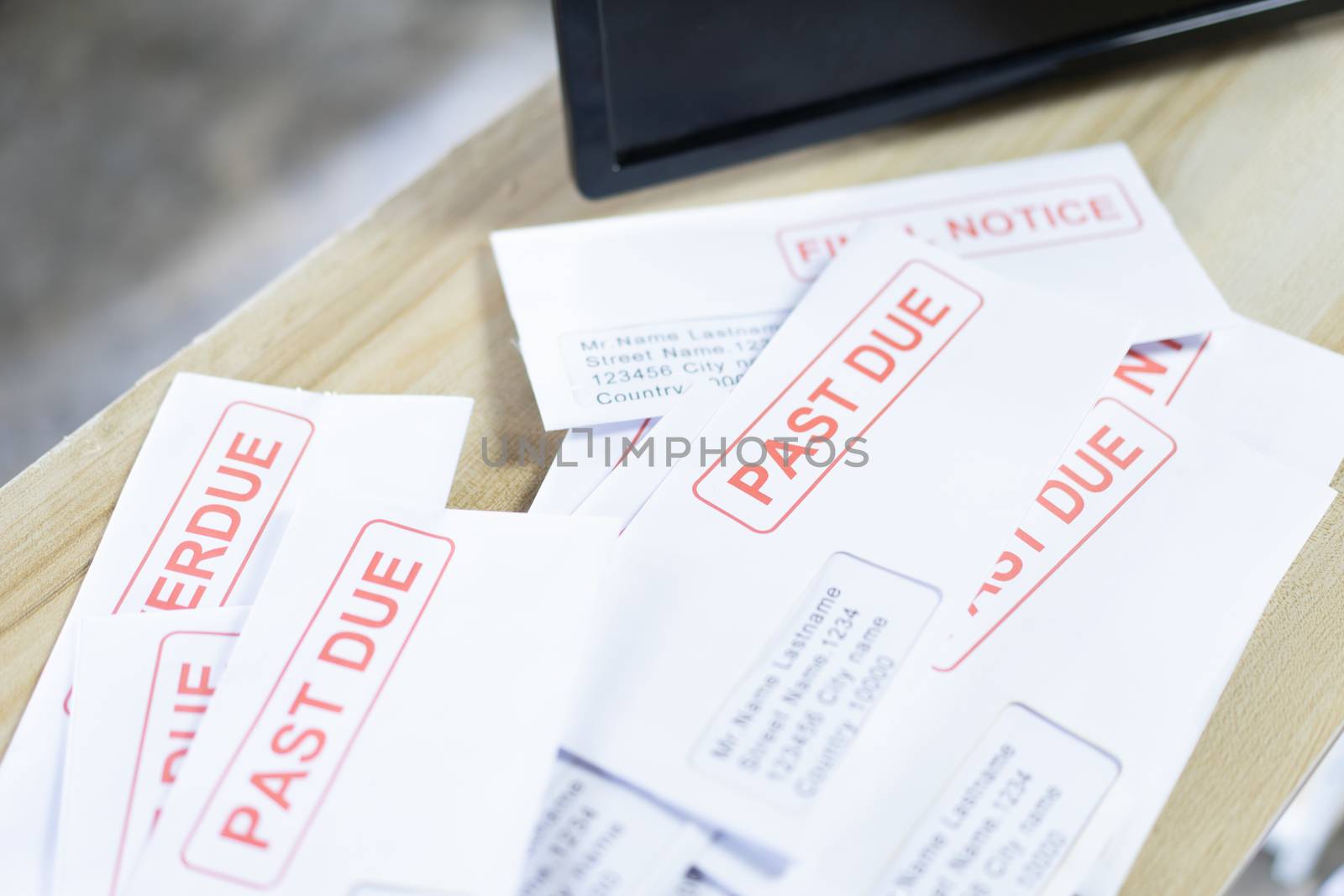 Debt letters that are collected on past overdue bills and final announcements on the table. Red writing to represent the struggle against economic unemployment.