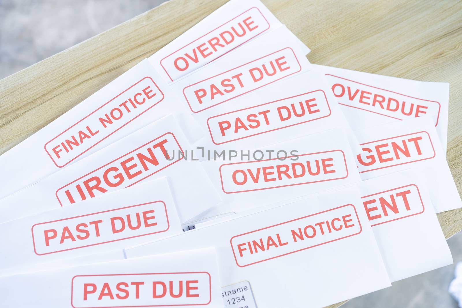 Debt letters that are collected on past overdue bills and final announcements on the table. Red writing to represent the struggle against economic unemployment.



J