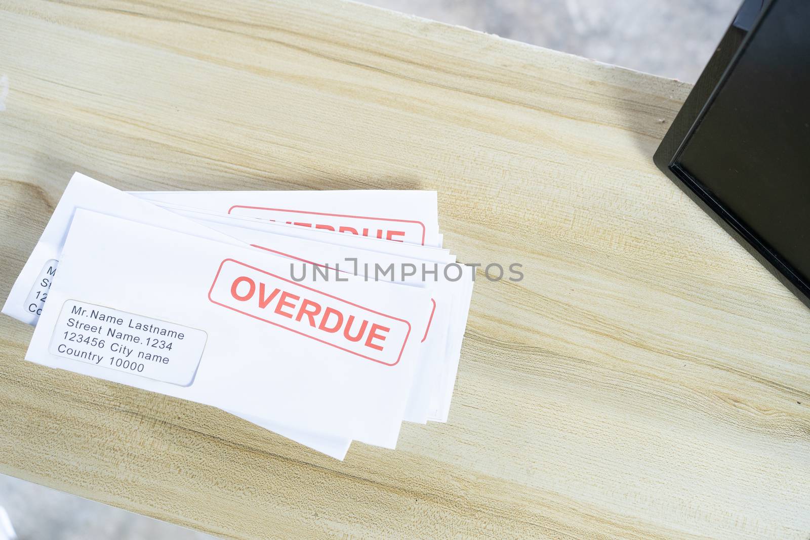 Debt letters that are collected on past overdue bills and final announcements on the table. Red writing to represent the struggle against economic unemployment.