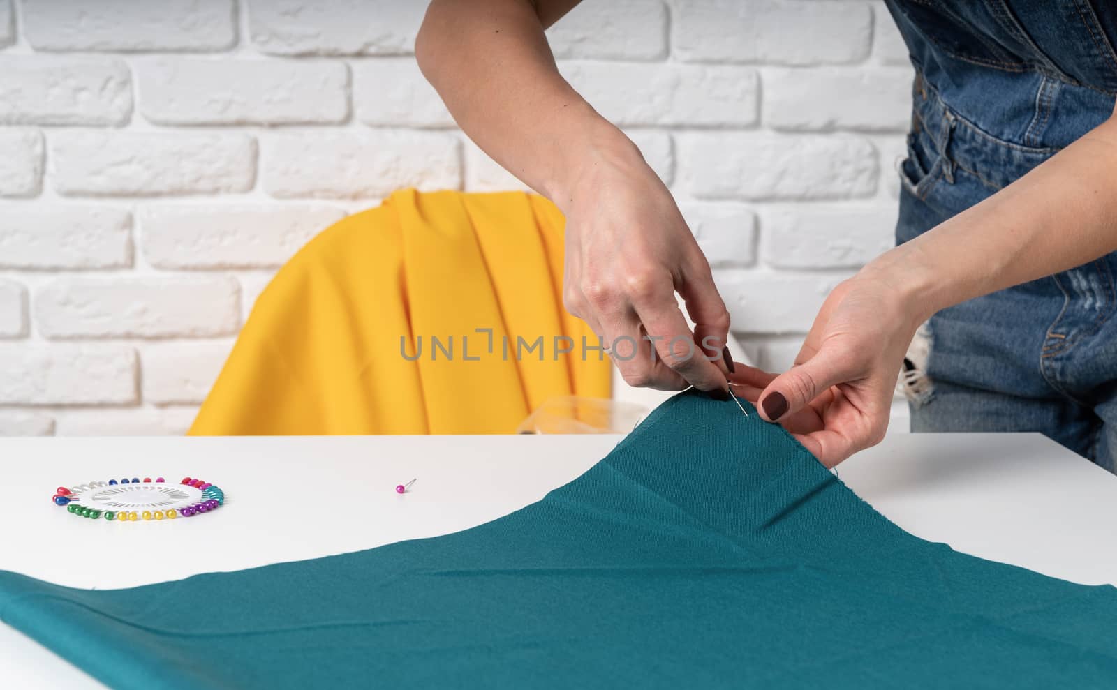 Woman tailor working with textile in her studio by Desperada