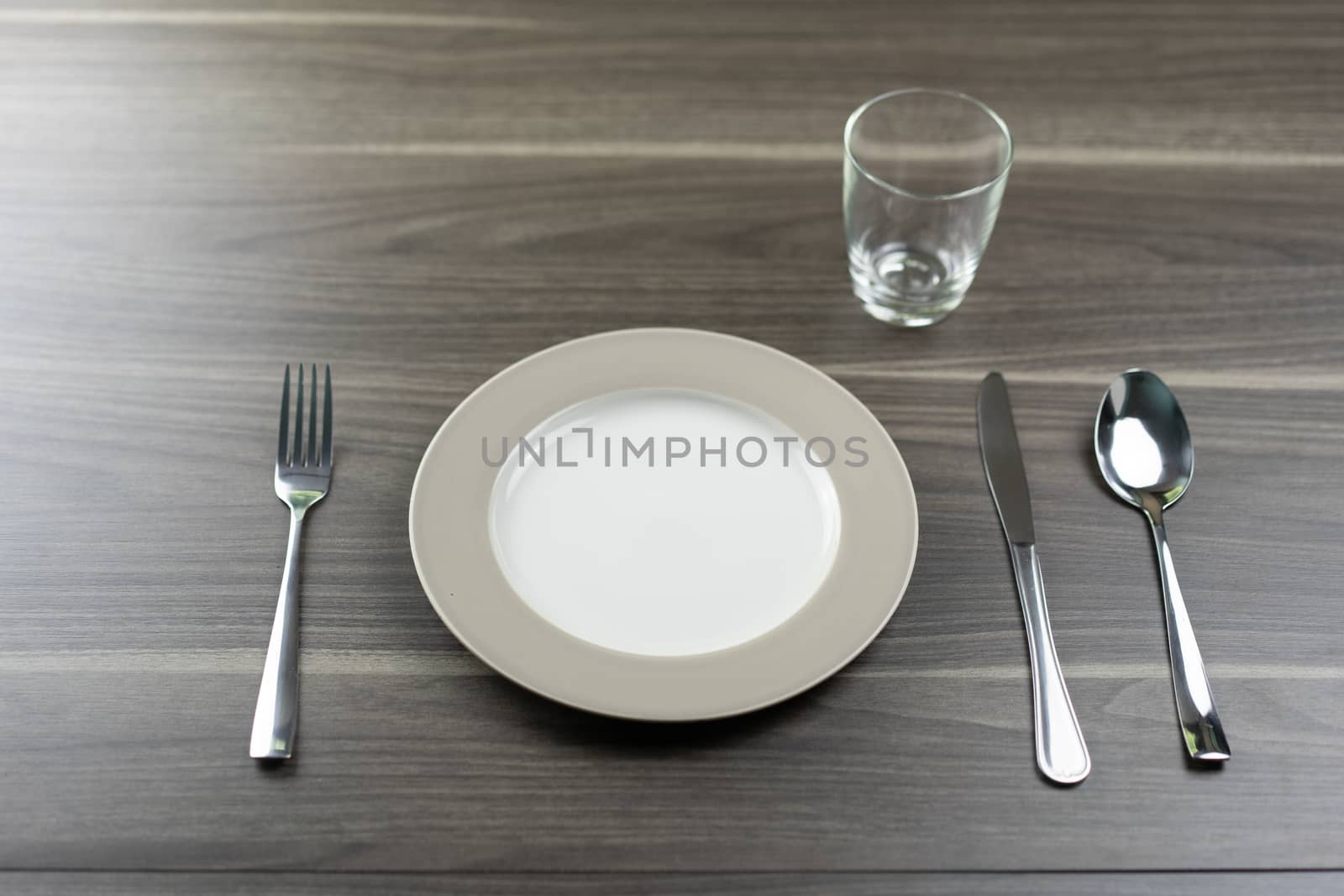 Spoon knives and empty dishes on a wooden table