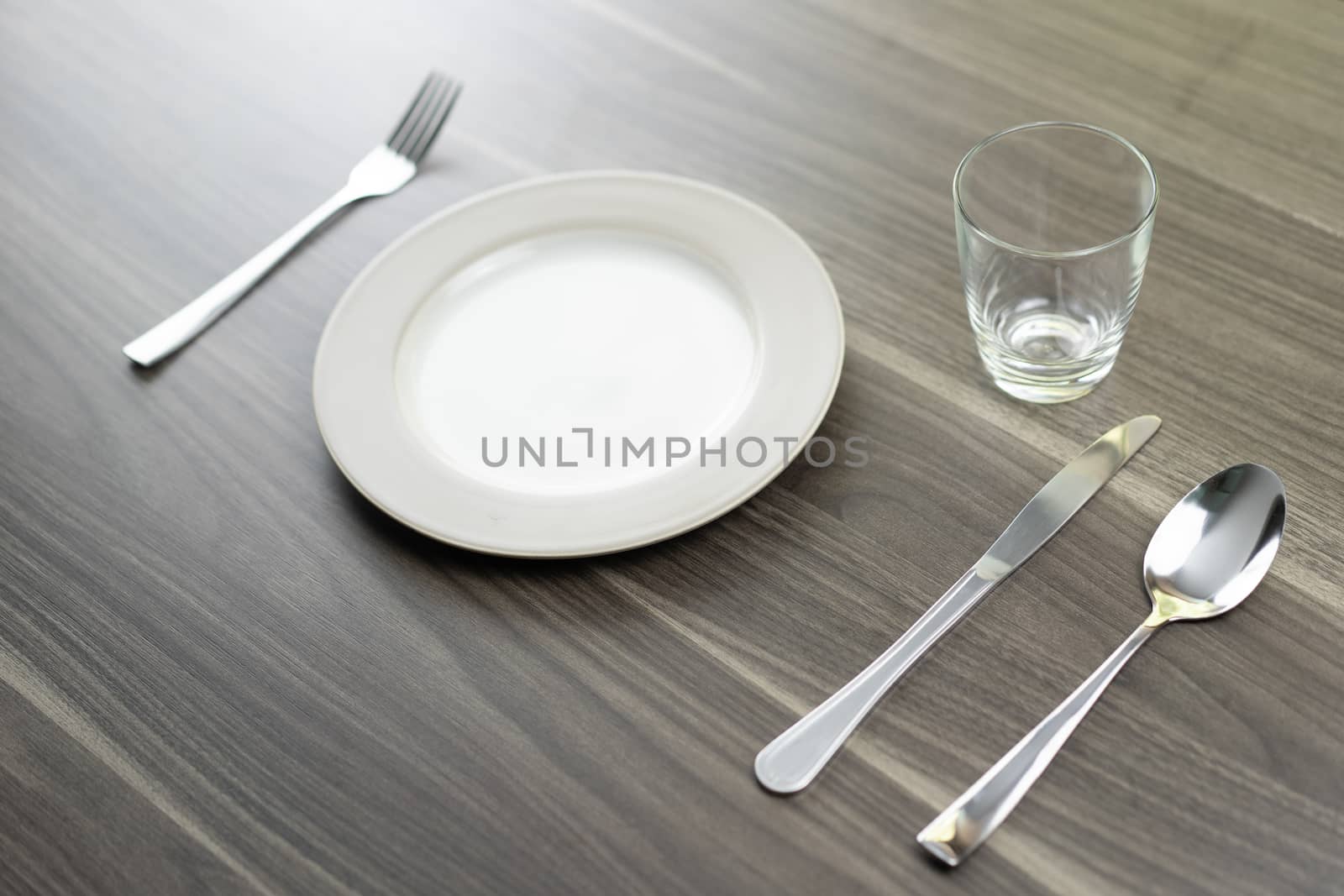 Spoon knives and empty dishes on a wooden table