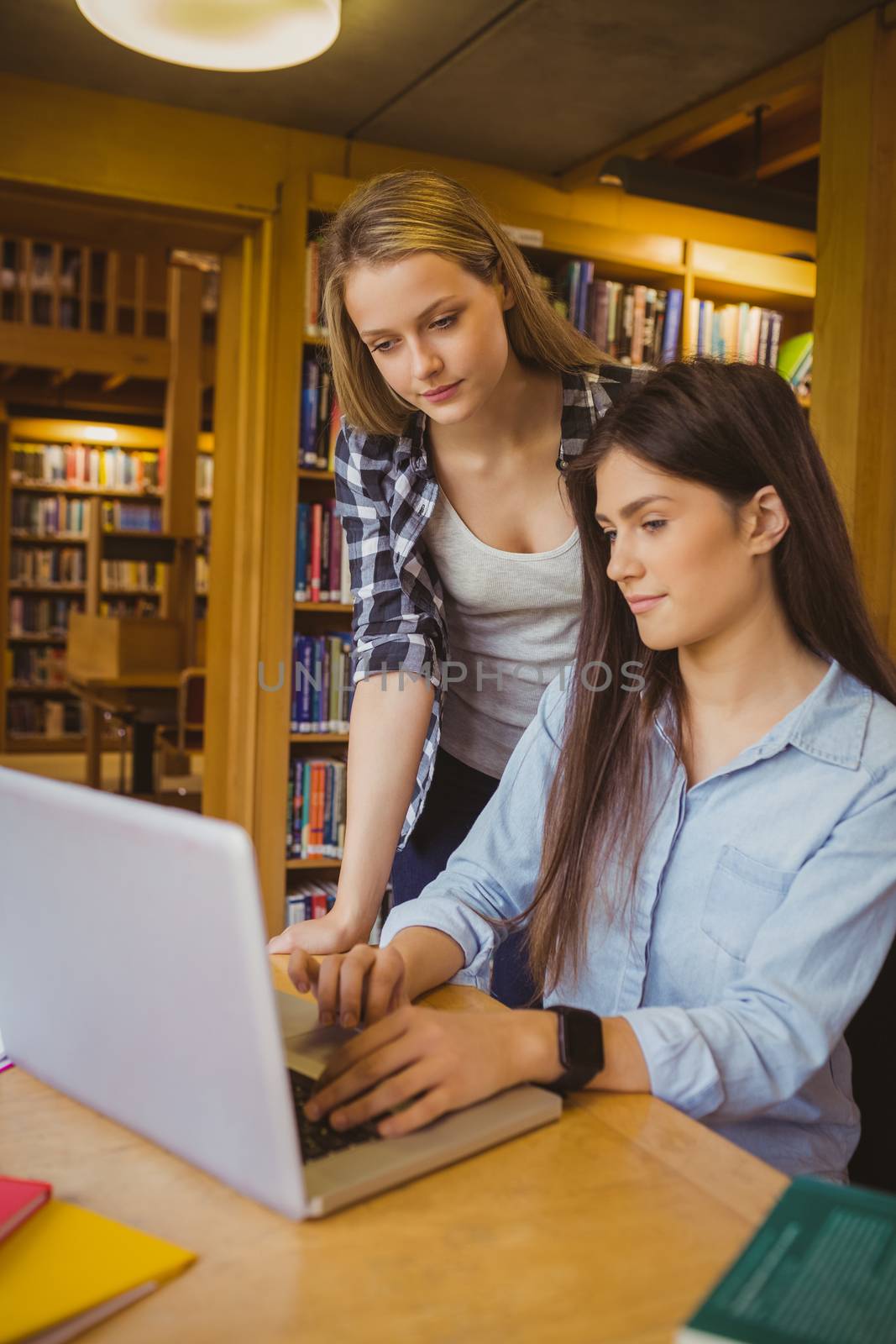 Serious students using laptop in library 