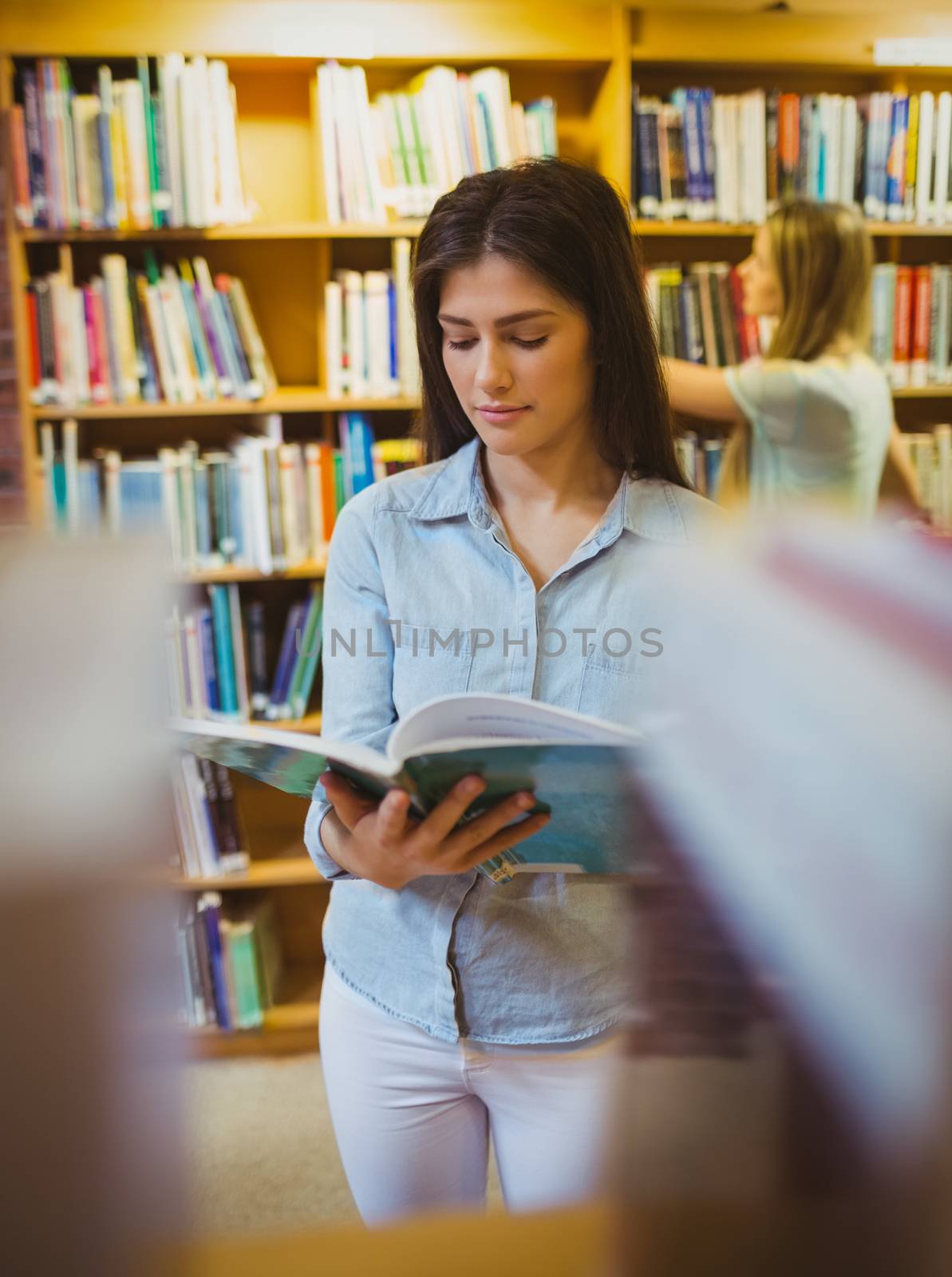Pretty young brunette reading book by Wavebreakmedia