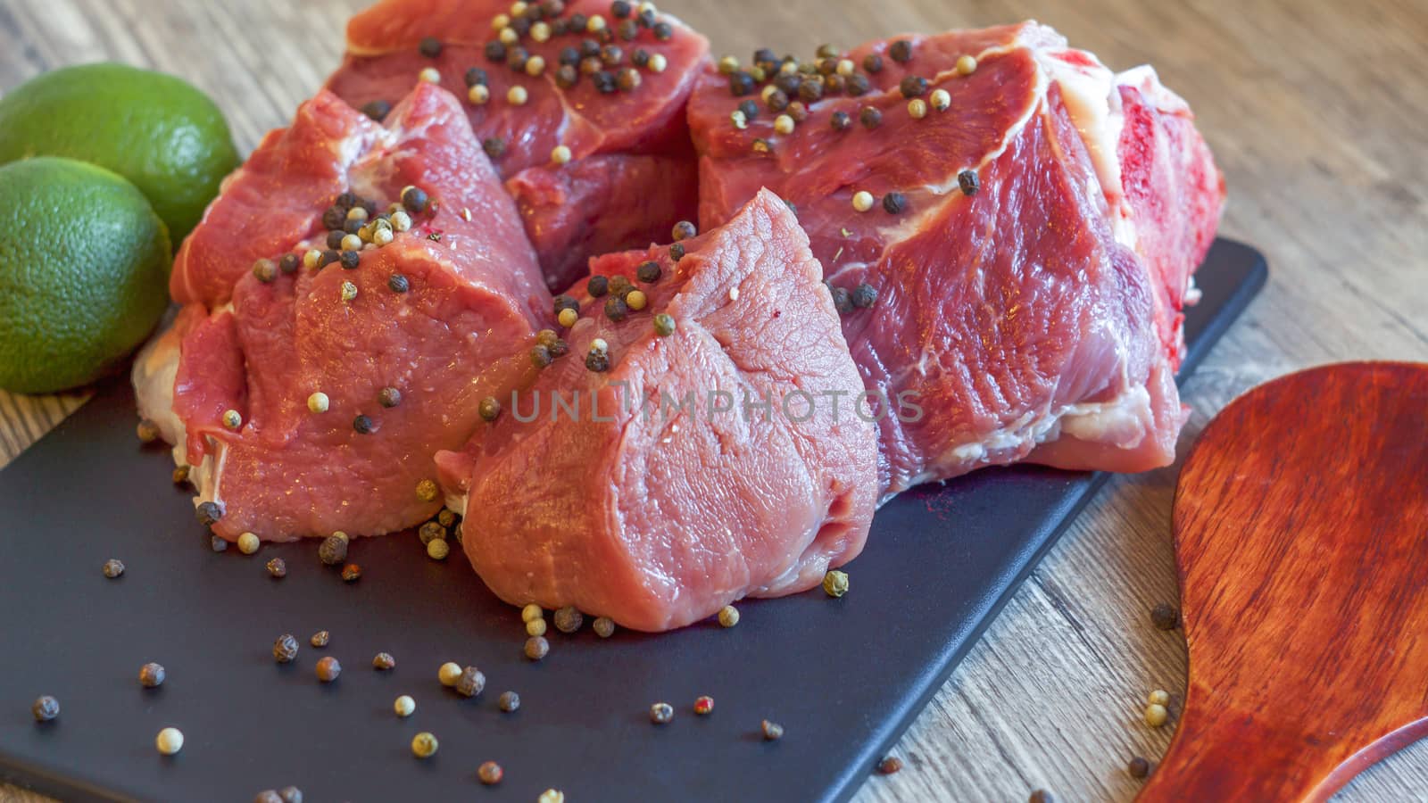 Red meat on a black Board sprinkled with pepper, garlic, anise a by YevgeniySam