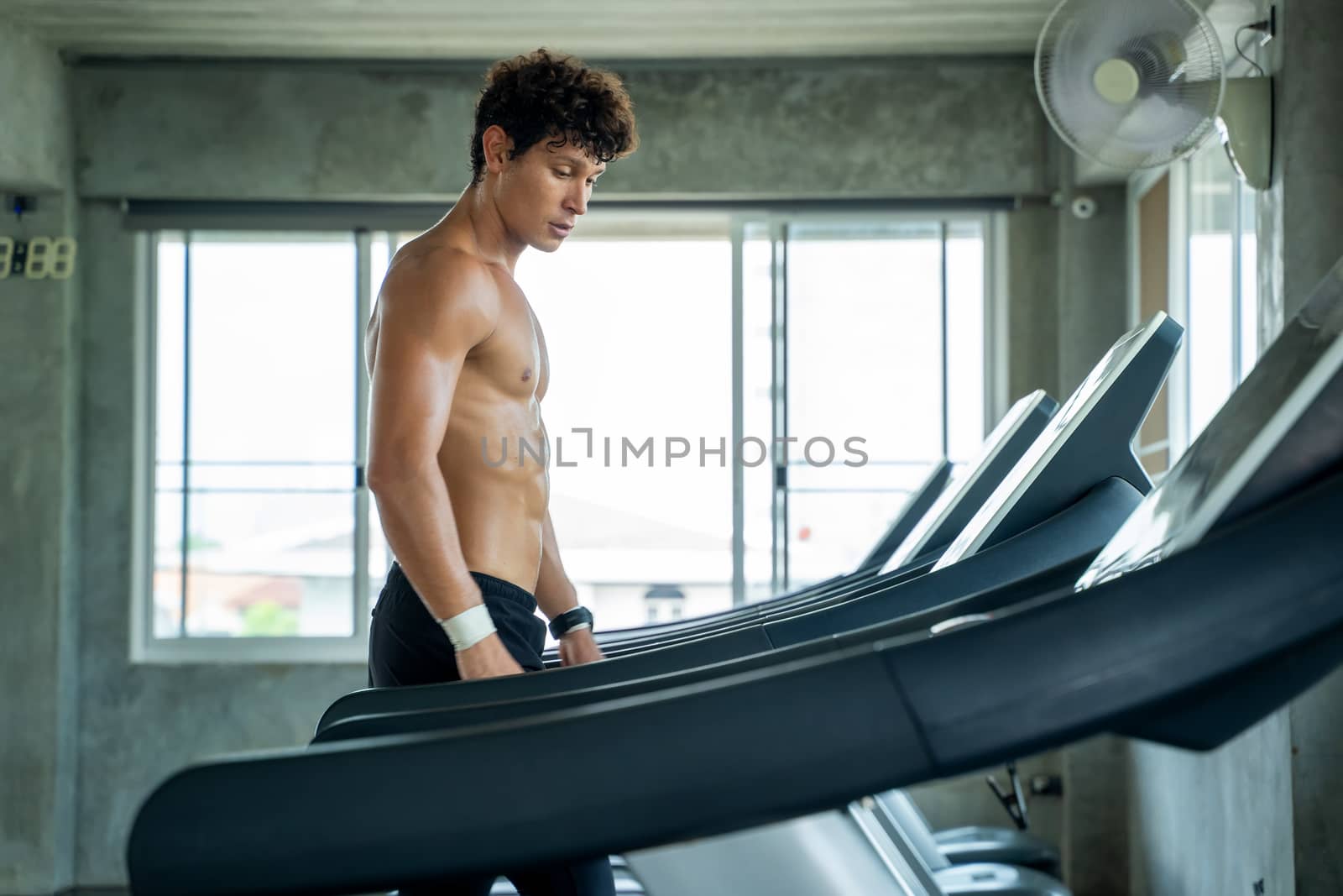 Man running in machine treadmill at fitness gym,sport, fitness. by Visoot