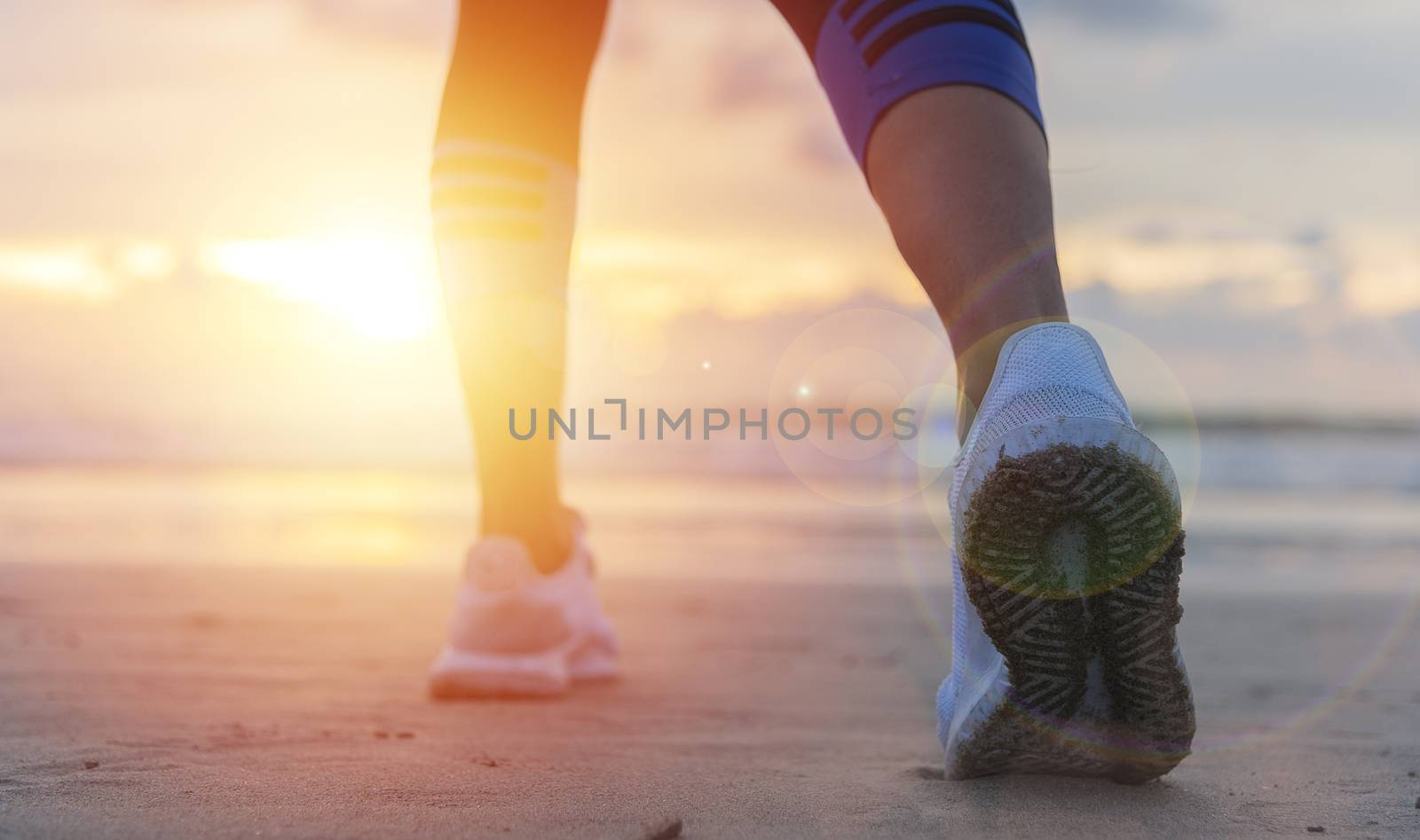 Woman running on the beach at sunrise closeup on shoe. Patong beach, Phuket, Thailand